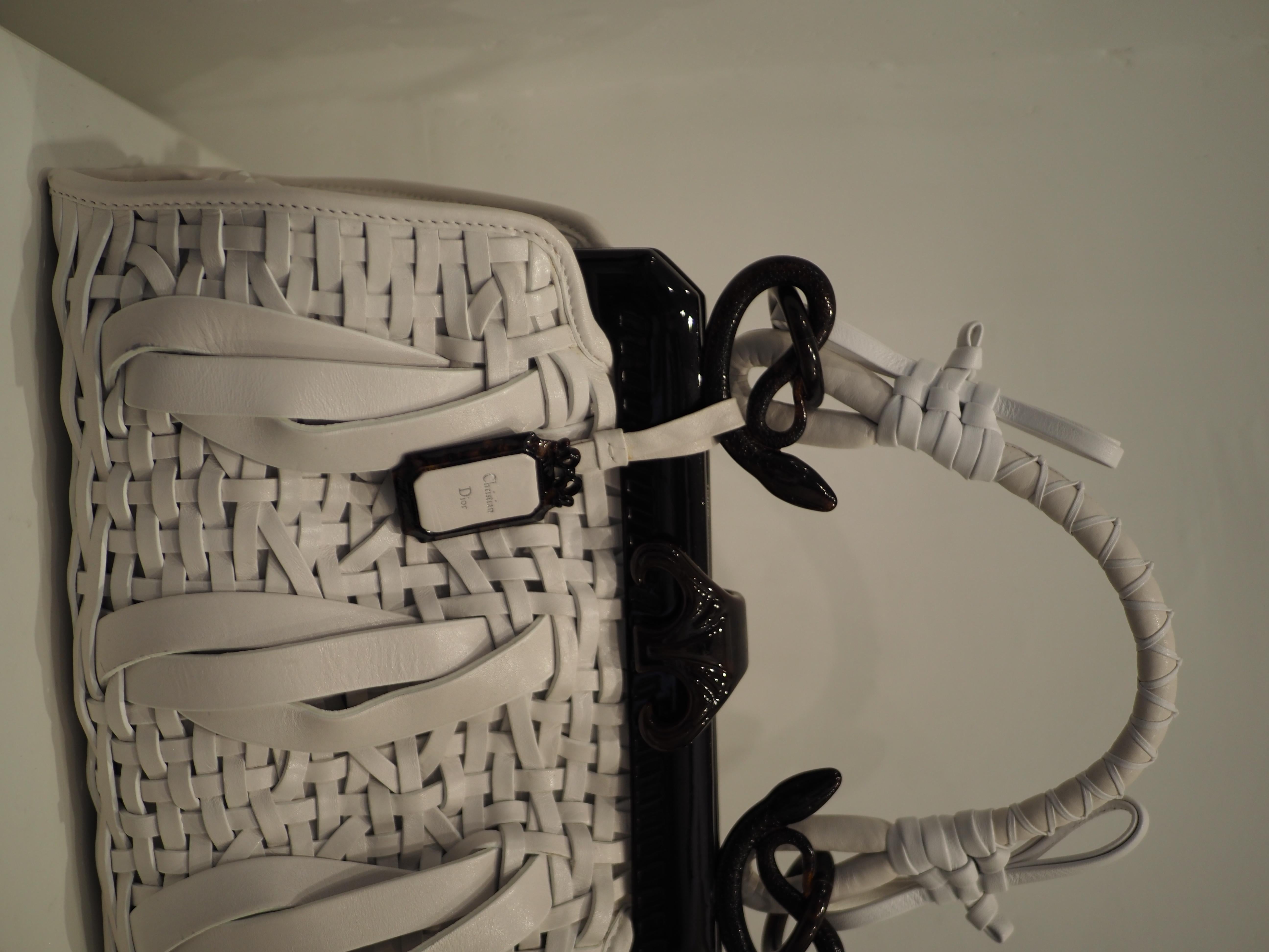 Christian Dior white and black samourai handle bag NWOT
totally made with white leather and bakelite hardware
Designed by John Galliano for the 60th anniversary of Dior. Comprised of white woven calfskin leather, brown Bakelite frame with snake
