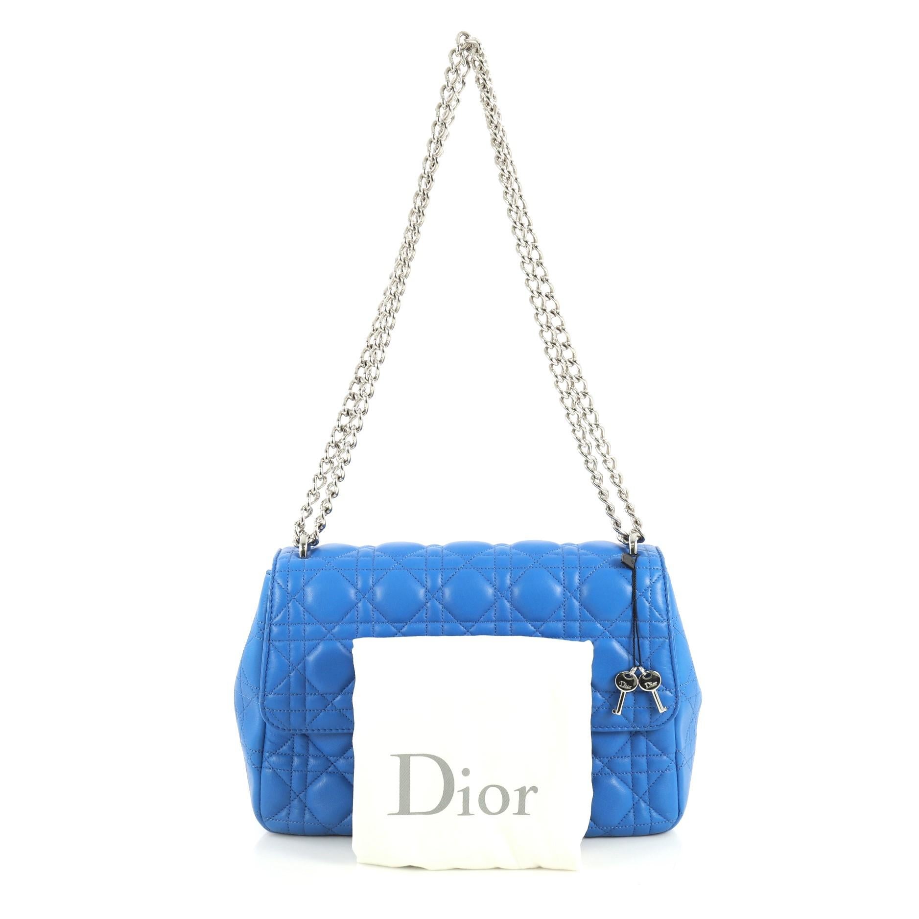 This Christian Dior Long Chain Miss Dior Bag Cannage Quilt Lambskin Medium, crafted in blue cannage quilted lambskin leather, features long chain link strap and silver-tone hardware. Its push-lock closure opens to a pink leather interior with slip