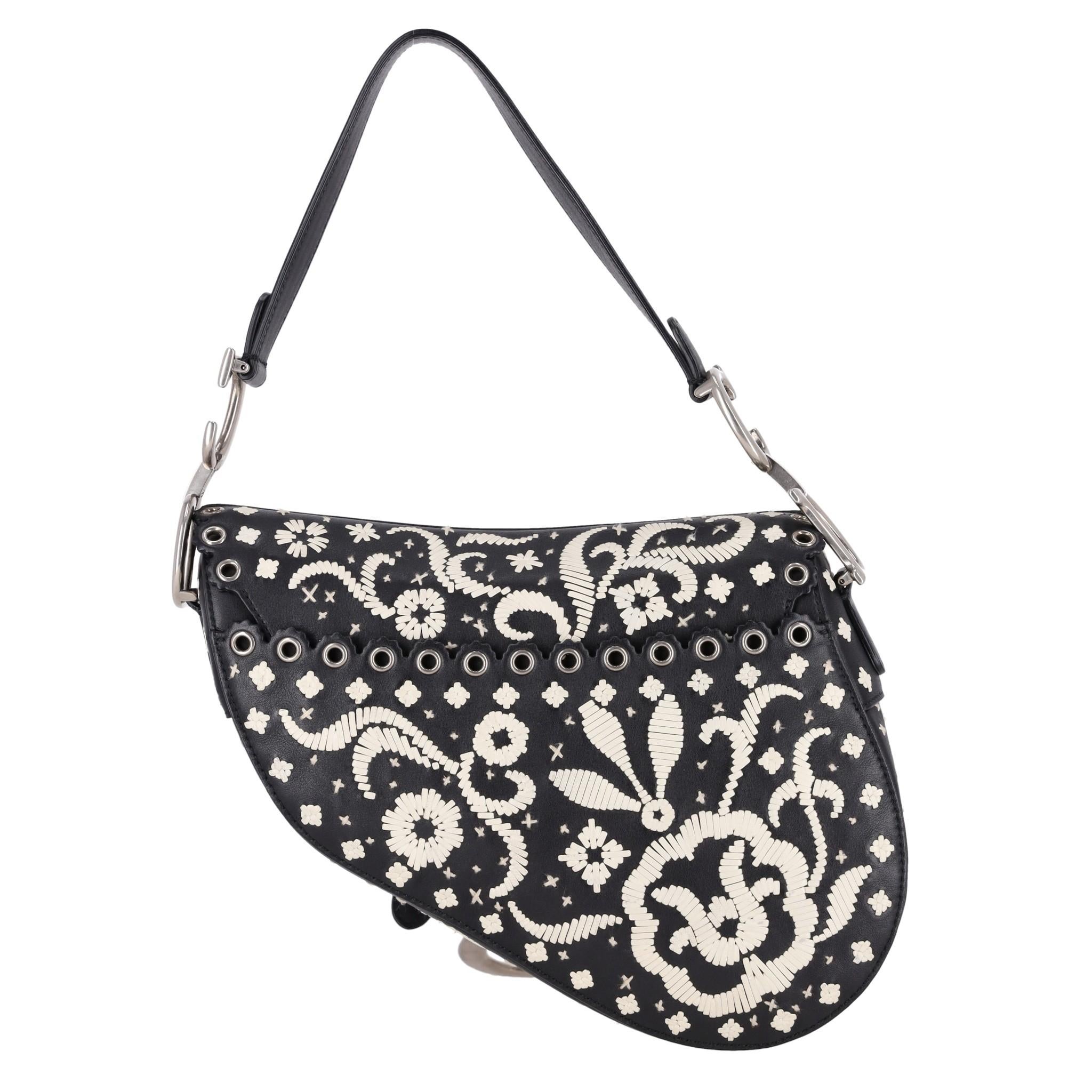 Christian Dior Ltd Edition Leather Embroidered Saddle Bag

Black shoulder bag designed with white leather Paisley embroidery.

Featuring silver eyelet trimmed front flap detailed with 'D' stirrup clasp with magnetic strap.

Styled with 'CD'