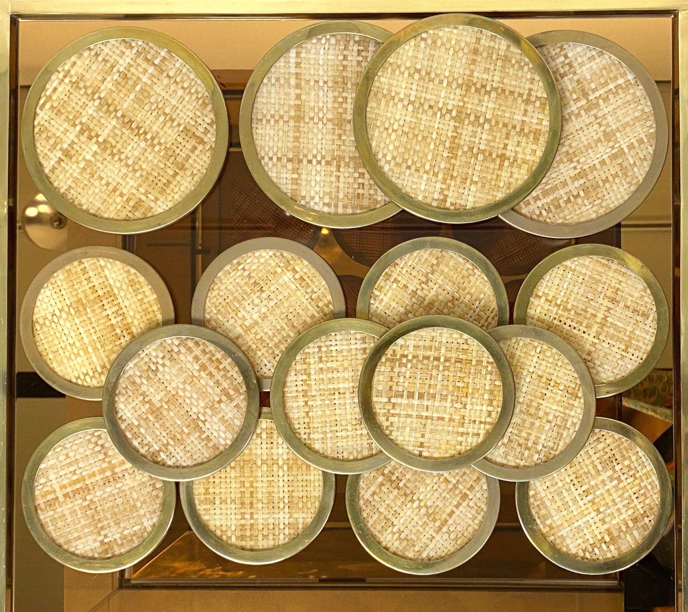 16 total pieces of barware coasters in Lucite and wicker with a brass frame by Christian Dior Home, France, 1970s.

- 12 small size for glasses (diameter 12 cm)
- 4 large size for bottles (diameter 16 cm).