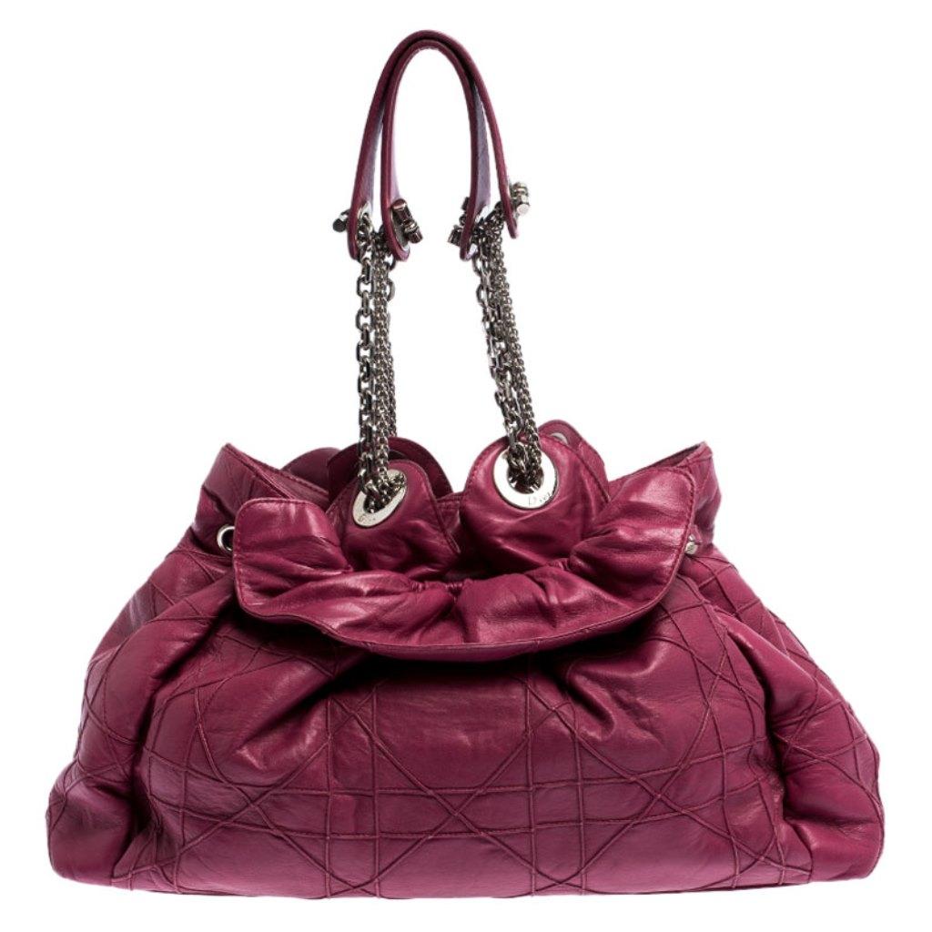 This stylish Le Trente bag from Christian Dior has been crafted from magenta leather and styled with their signature cannage pattern. The bag features dual chain handles with leather shoulder rest, a CD cutout charm, a drawstring closure and