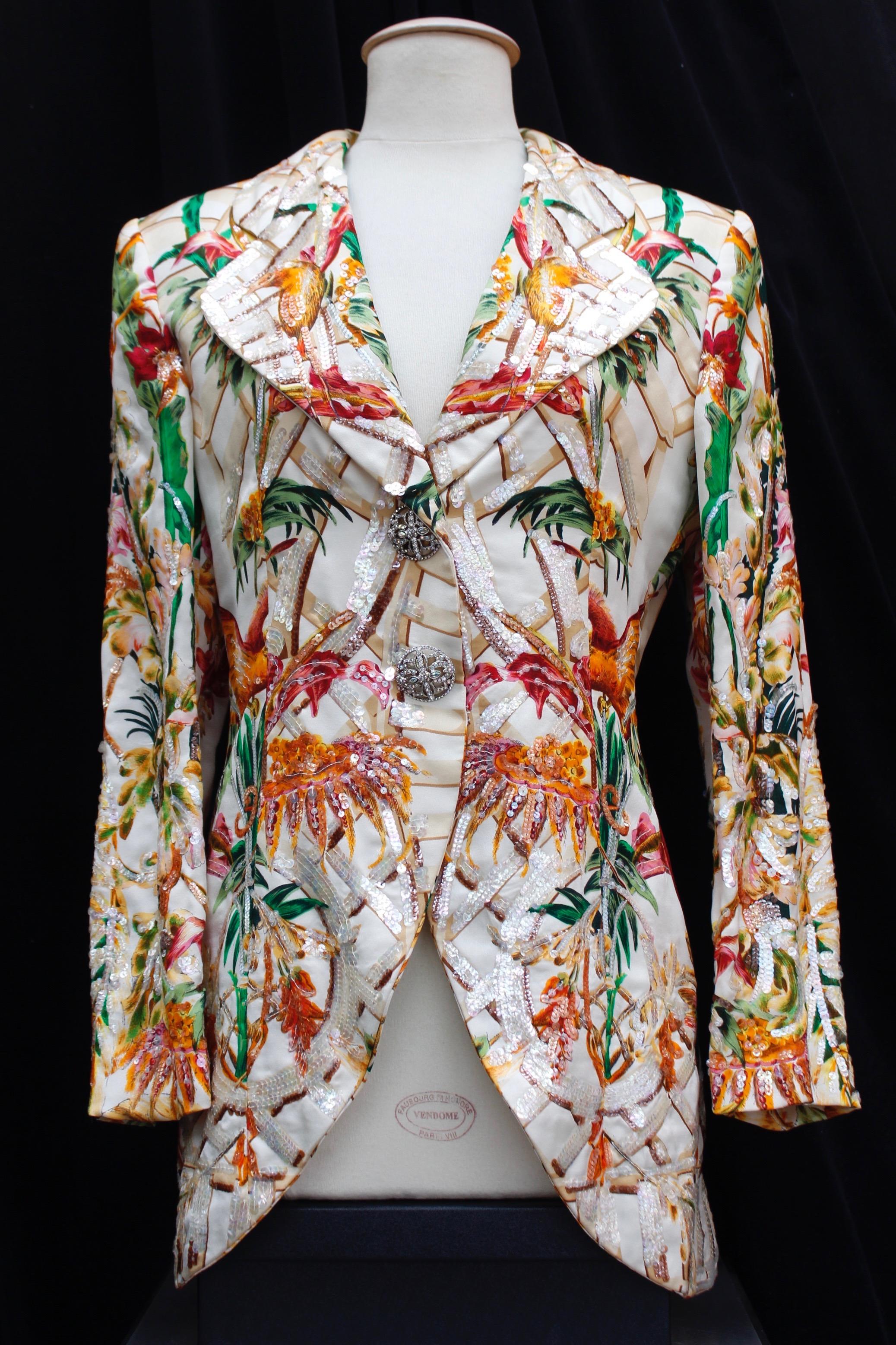 CHRISTIAN DIOR BOUTIQUE – Magnificent long sleeve jacket with tailored collar, composed of off-white silk printed with flowers, trellis and birds pattern in yellow, green, pink, brown, orange and red colors. Some parts are embroidered with pearly
