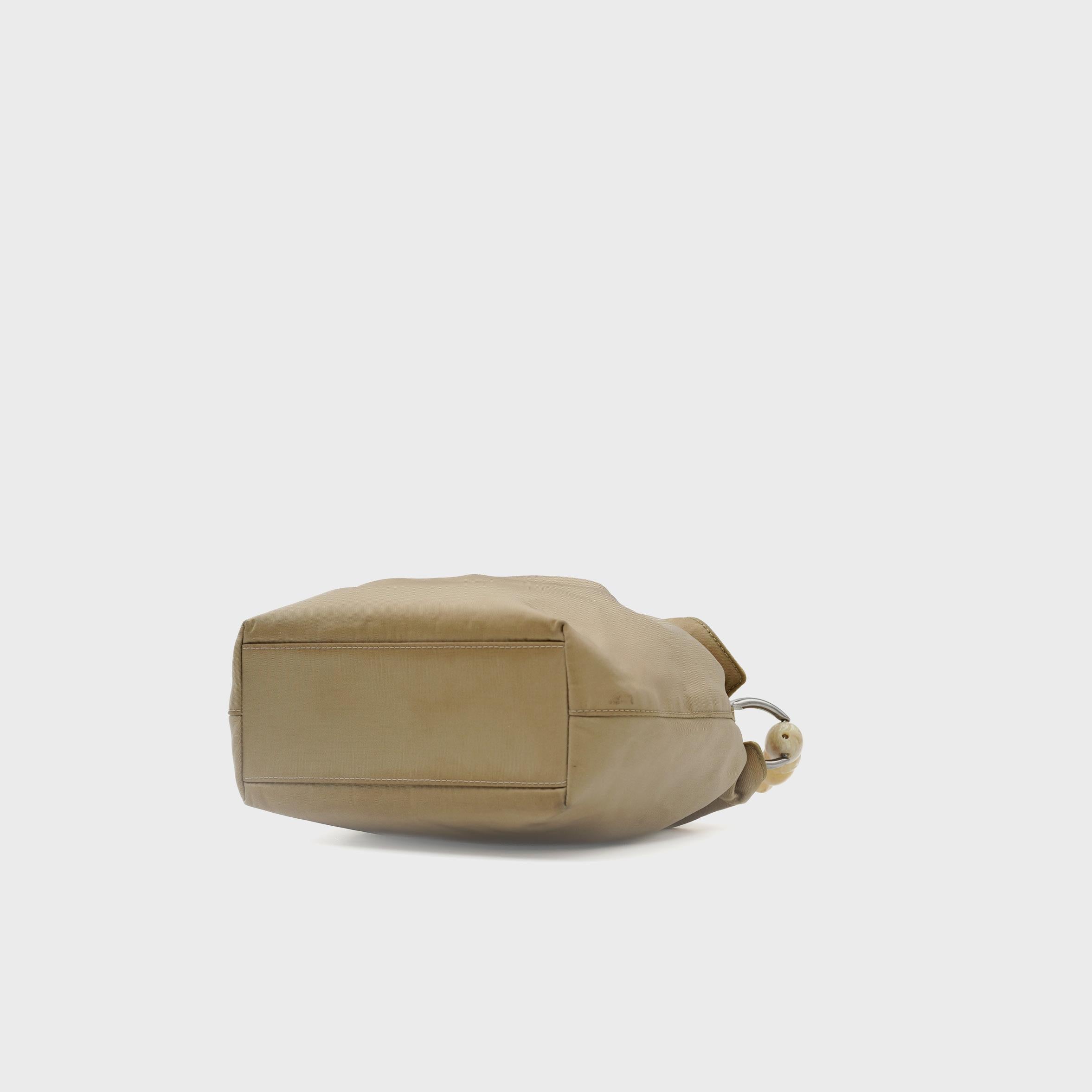Conçu par John Galliano pour Christian Dior aux alentours de l'an 2000, le sac Malice incarne l'esprit expérimental et surréaliste qui a défini la maison au début des années 2000. Confectionné en France à partir d'une toile beige lisse, il présente