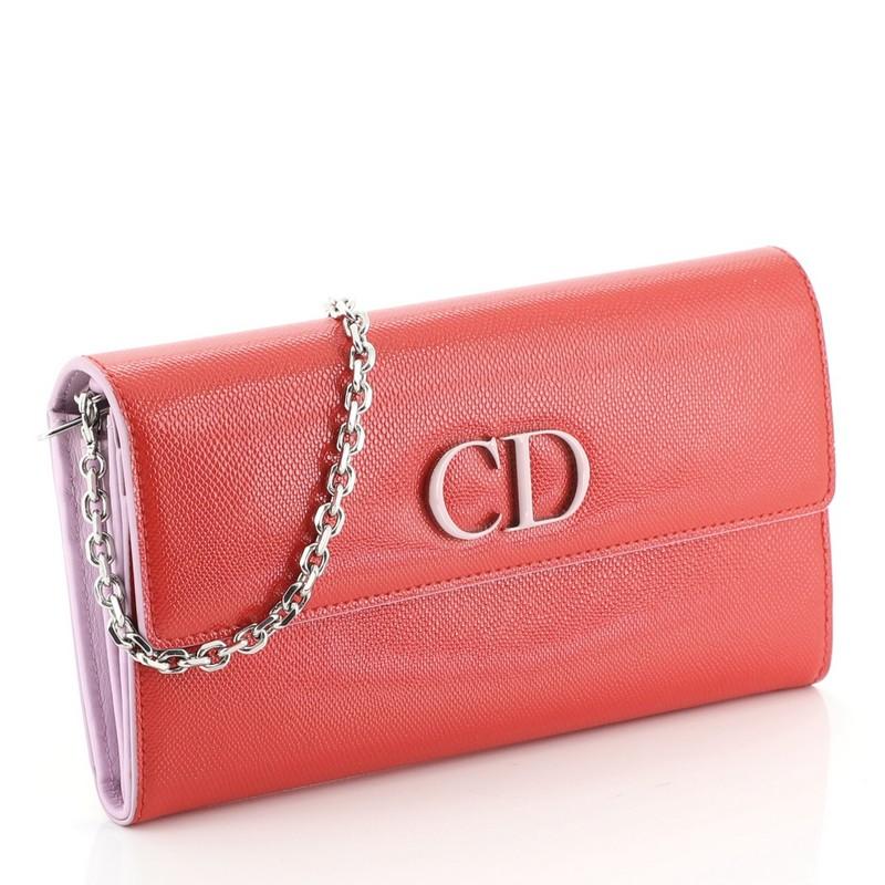 This Christian Dior Mania Rendez Vous Wallet on Chain Leather, crafted in red leather, features a detachable chain strap, Dior’s signature 'CD' logo and silver-tone hardware. Its snap button closure opens to a purple leather interior with multiple