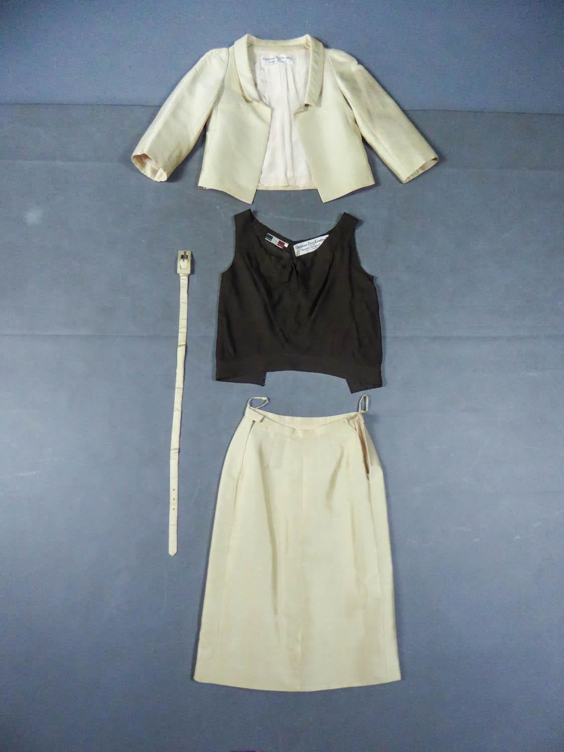 Circa 1962
France - England

Demi Couture Christian Dior skirt suit set dating from the beginning of the direction of Mr. Marc Bohan at the head of the famous House around 1962. Suit in champagne cream gazar and brown silk crepe top. Open jacket
