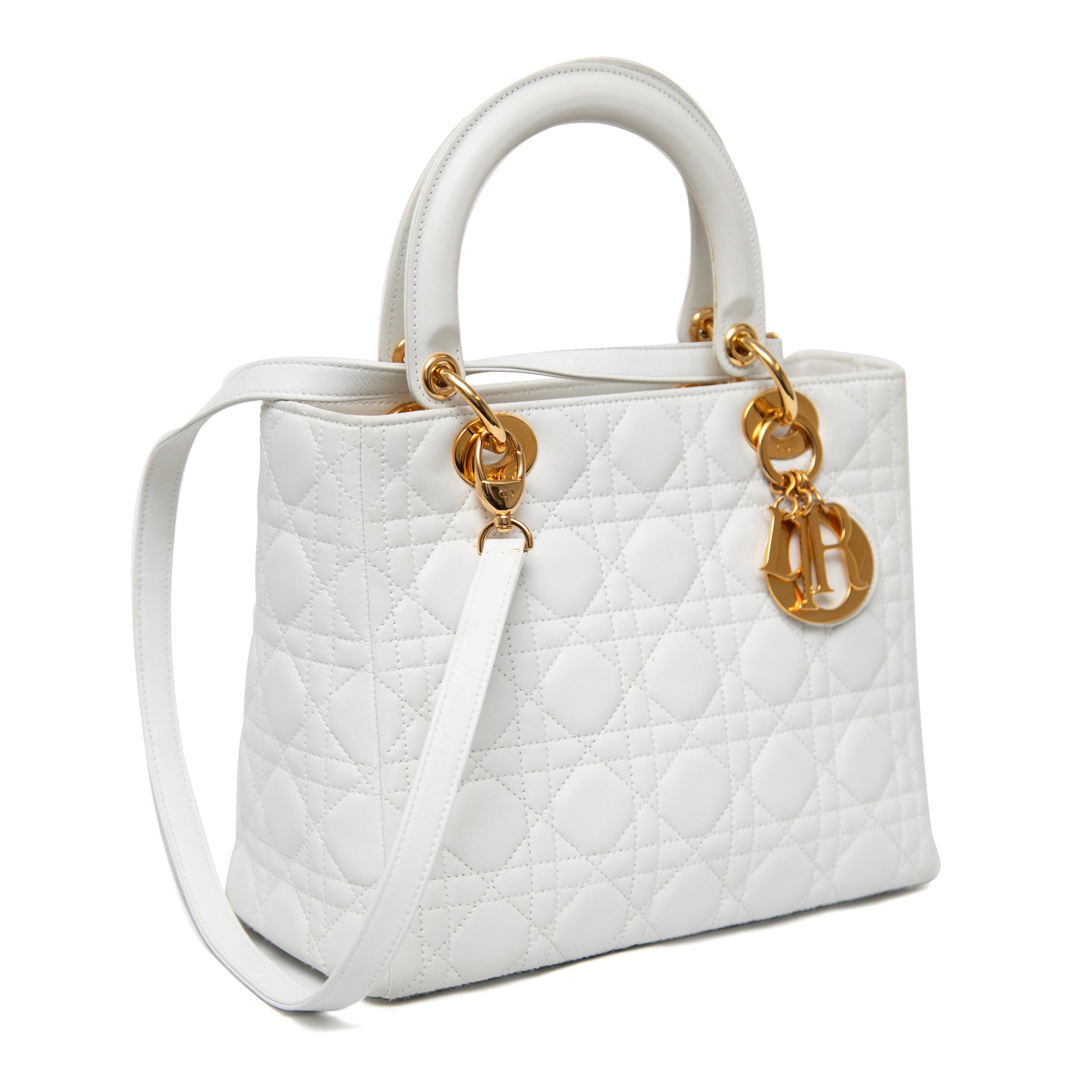This Christian Dior Lady Dior Medium Bag in snow-white lambskin is an embodiment of timeless elegance. Featuring the iconic quilted cannage stitching and adorned with a single gold-toned 'D.I.O.R.' charm, this bag combines luxury and classic Dior