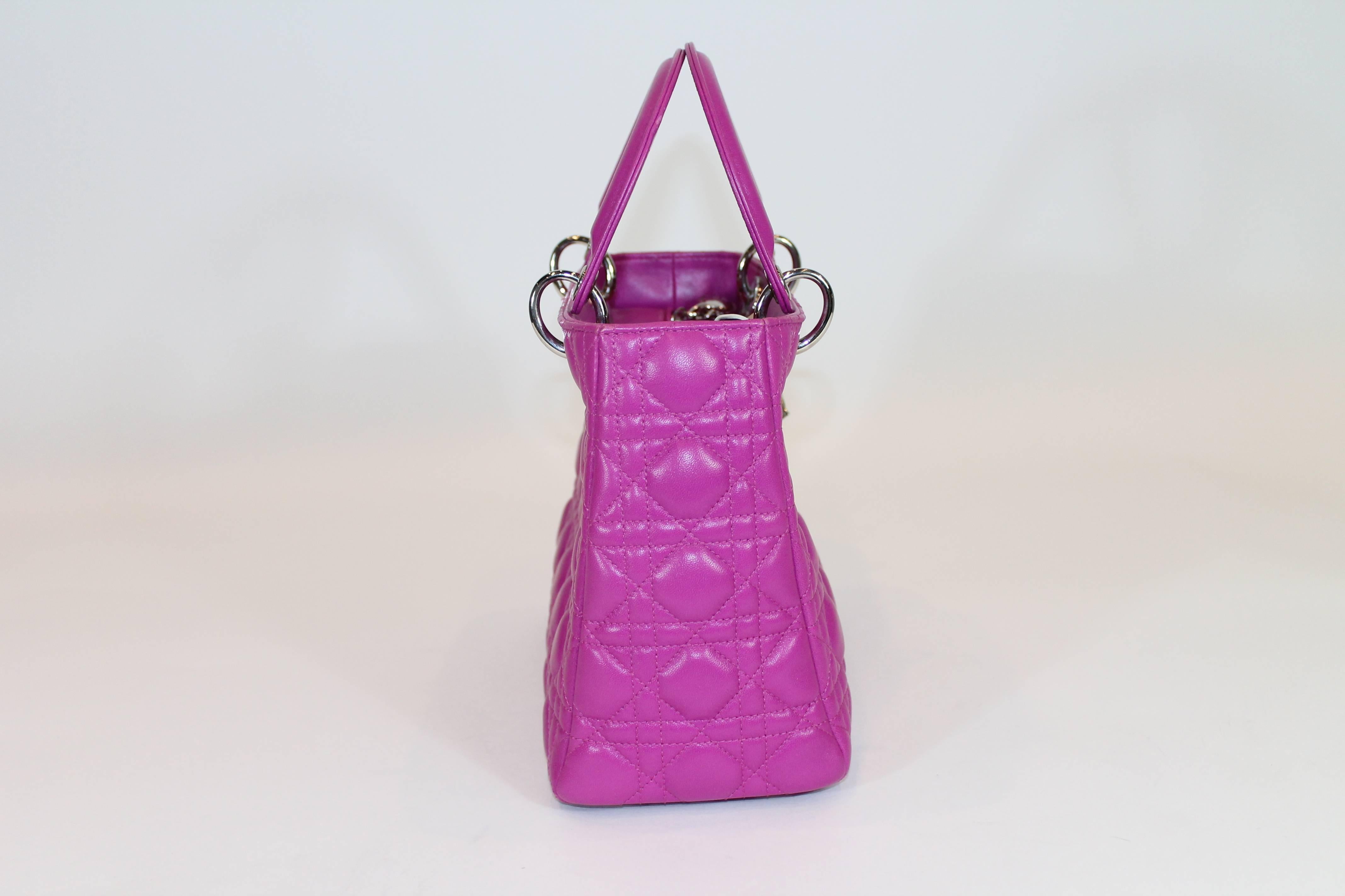 Fuchsia Cannage leather. Silver-tone hardware. Dual flat top handles. Featuring logo charm accents. Protective feet at base, Zip closure at top. One interior zippered pocket. Detachable shoulder strap.