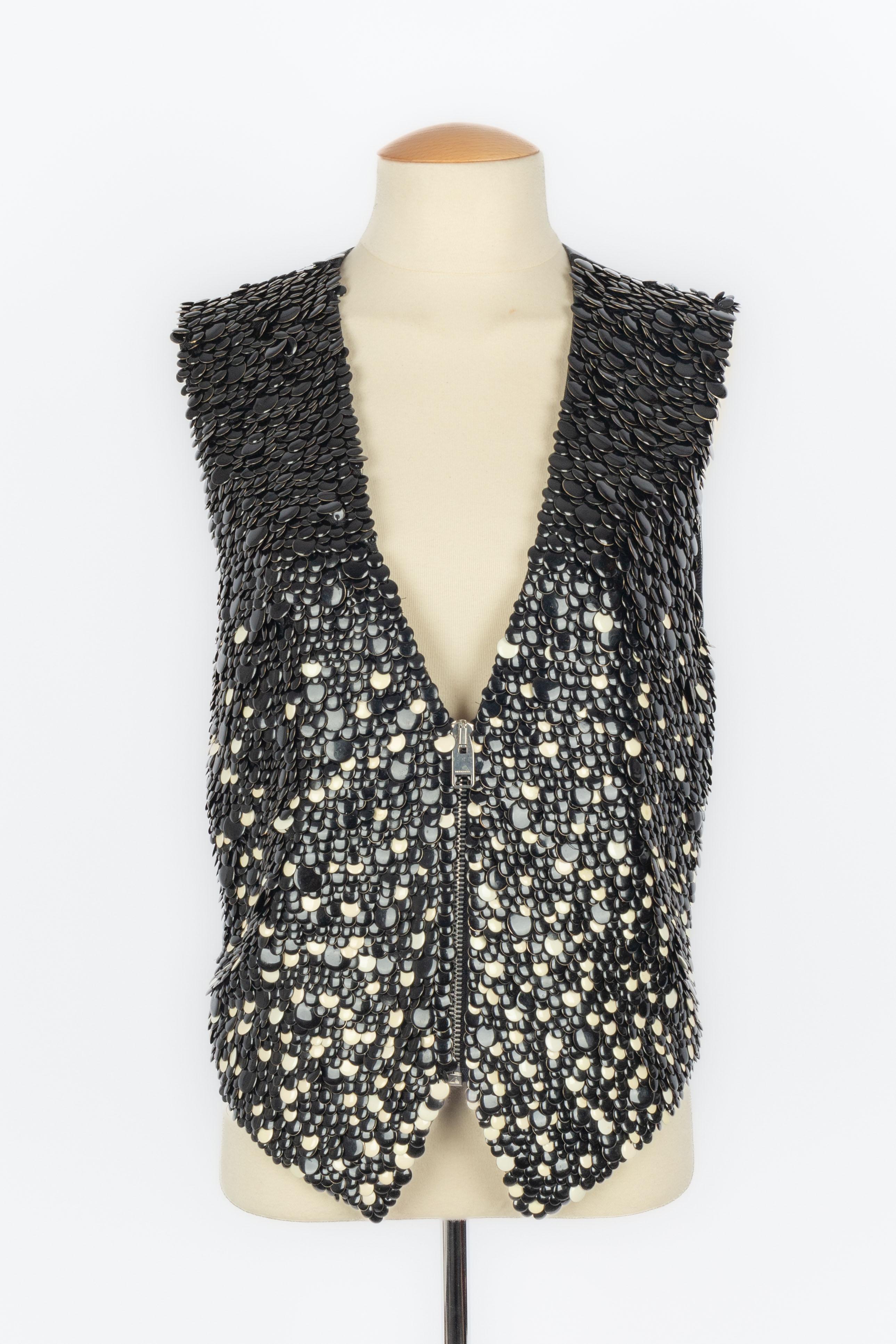 DIOR - (Fabriqué en Italie) Gilet en cuir noir brodé de paillettes émaillées noires et blanches. Taille 44IT indiquée, elle correspond à un 40FR. Collectional automne-hiver 2007 sous la direction artistique de Hedi Slimane.

Condit :
Très bon
