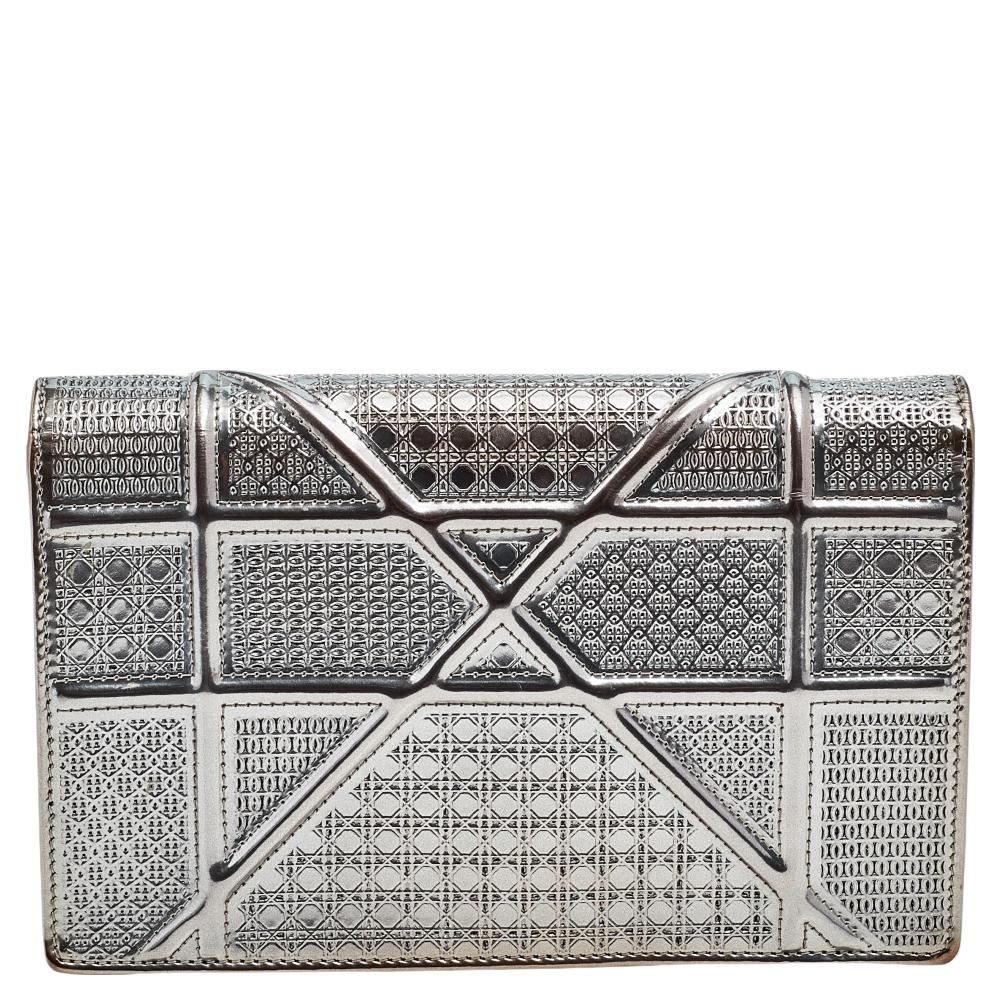 This Diorama wallet has been crafted from metallic grey leather and covered in the signature Microcannage pattern. Magnetic closure on the flap secures a leather-fabric interior, and a shoulder chain is provided for you to carry it. You will surely