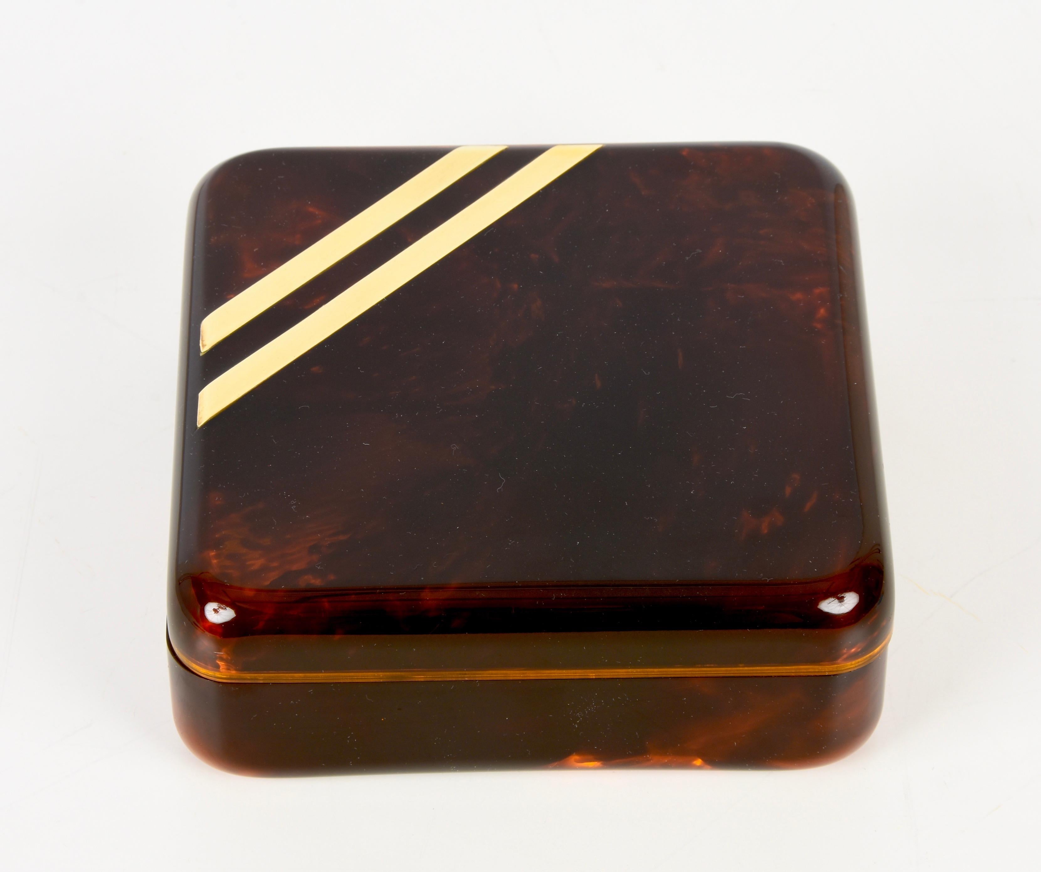 Amazing midcentury lucite and brass decorative jewelry box. This fantastic piece was designed in Italy during the 1970s for Christian Dior.

This piece, is in its unique elegance, simulates tortoiseshell with its lucite structure and has precious