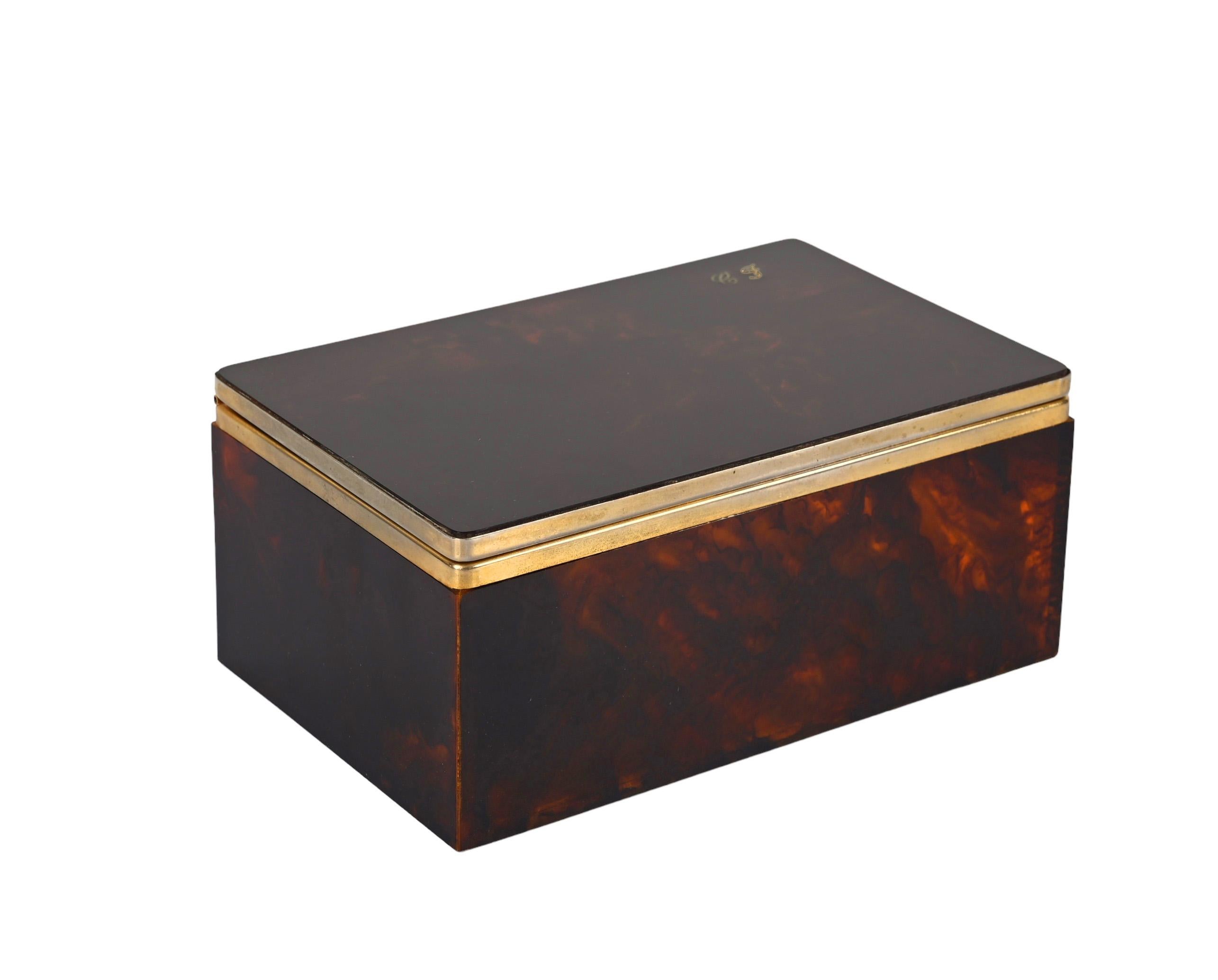 Amazing mid-century lucite and brass decorative jewelry box. This fantastic piece was designed in Italy during the 1970s for Christian Dior.

This piece, is in its unique elegance, simulates tortoiseshell with its lucite structure and has precious