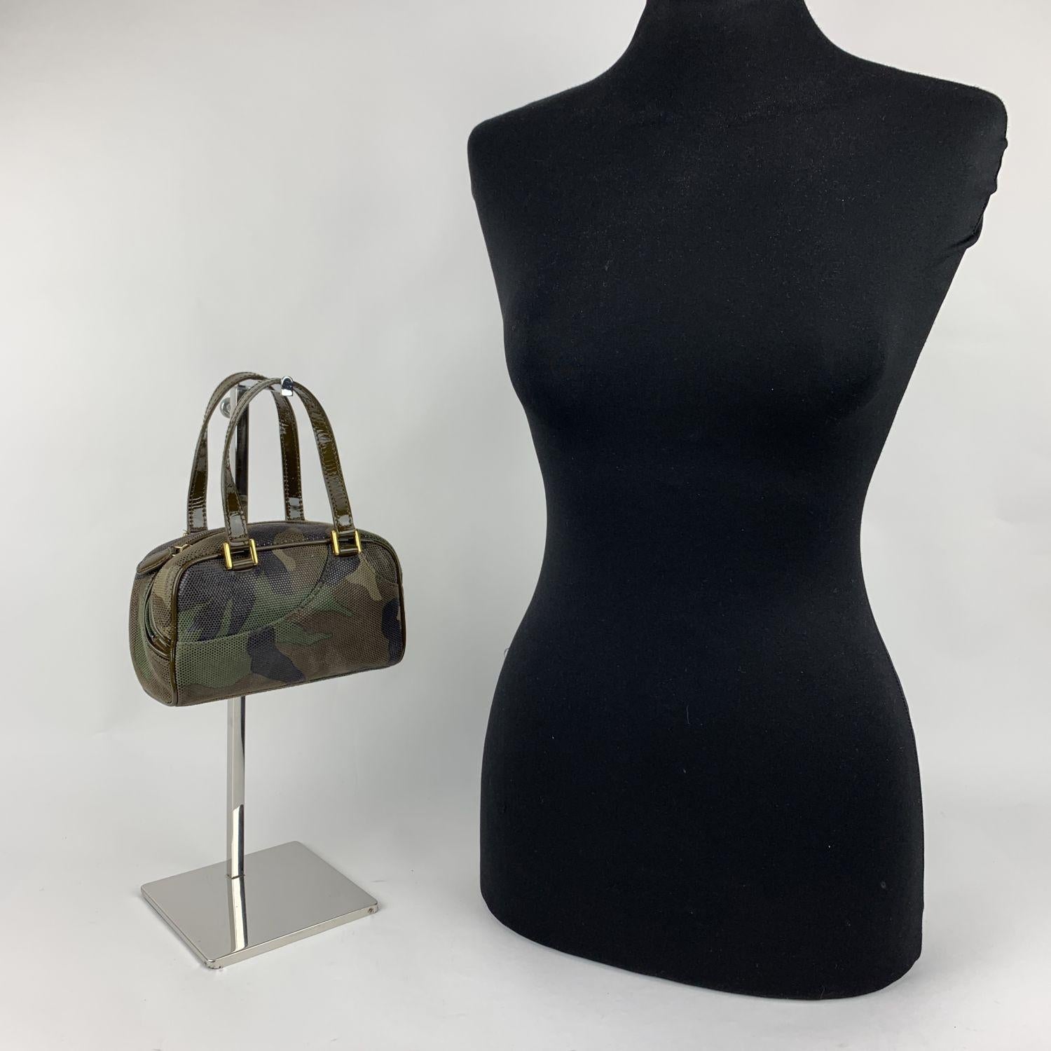 Mini Camouflage handbag by Christian Dior, from the Galliano era. Crafted from military Green camouflage canvas, it features double patent leather handles, upper zipper closure and 1 front open pocket. Canvas lining with 1 side zip pocket inside.