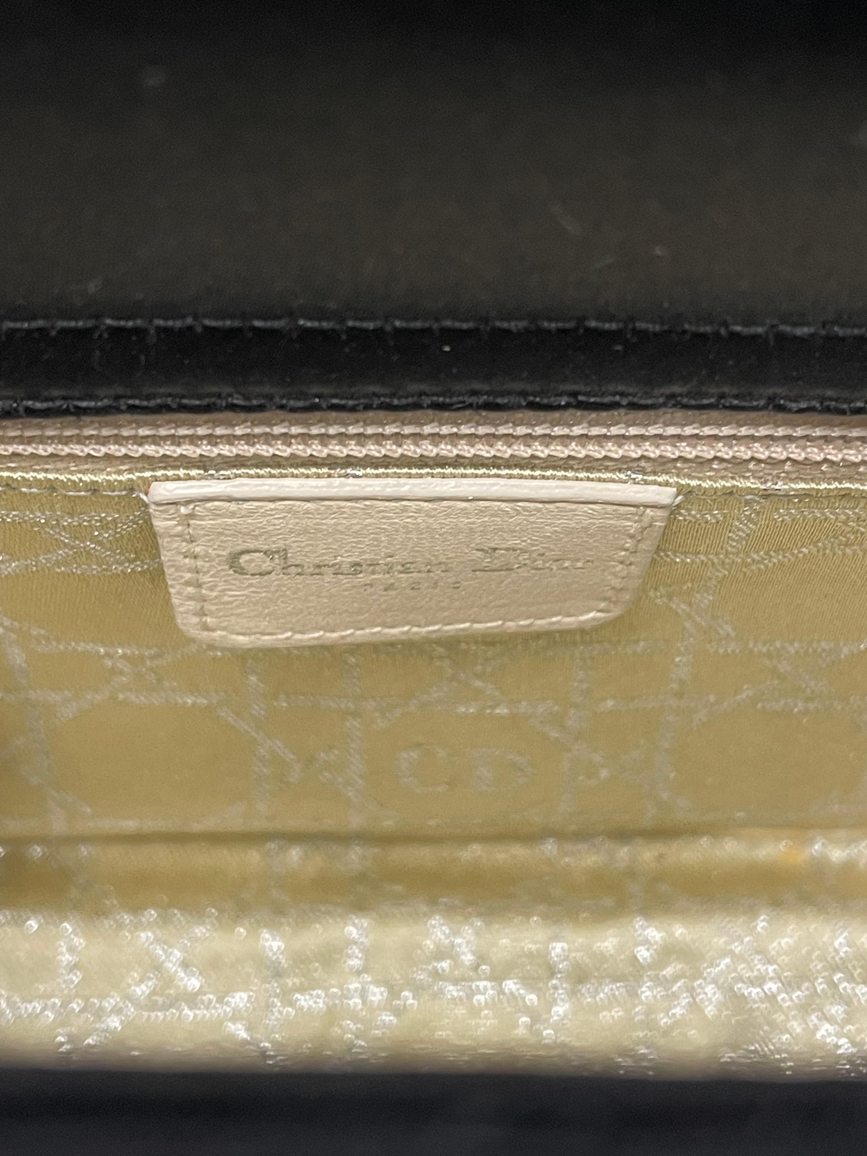 From the iconic 1998 collection by John Galliano, this vintage Christian Dior top handle bag is a true collector's piece. Made from luxurious black satin with a striking graphic print, it’s adorned with silver-tone hardware and crystal