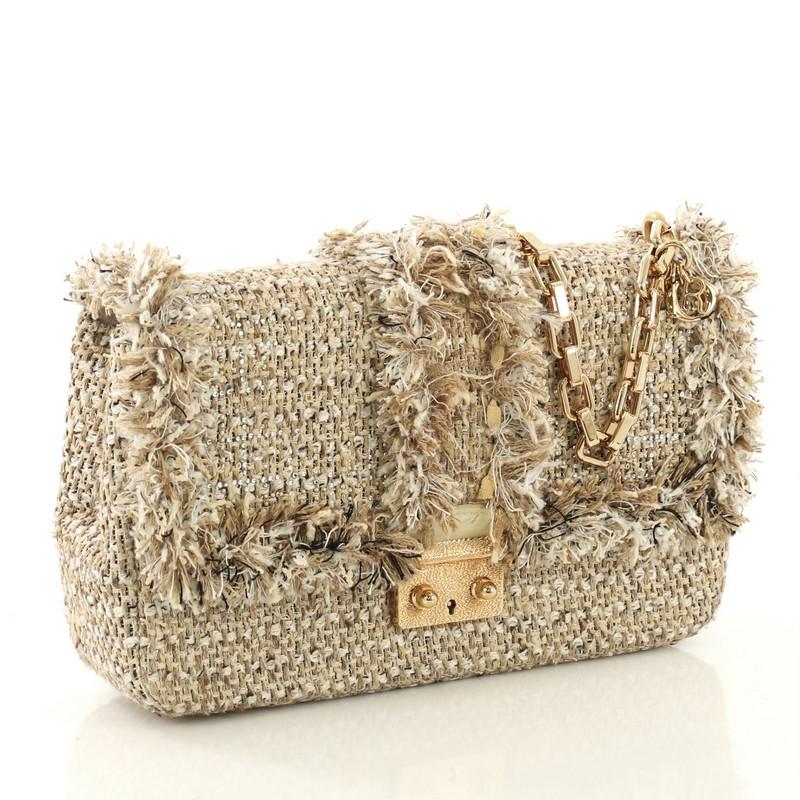 This Christian Dior Miss Dior Flap Bag Tweed Medium, crafted from beige tweed, features a chain link strap, frontal flap and gold-tone hardware. Its push-lock closure opens to a purple leather interior with slip pockets. 

Estimated Retail Price: