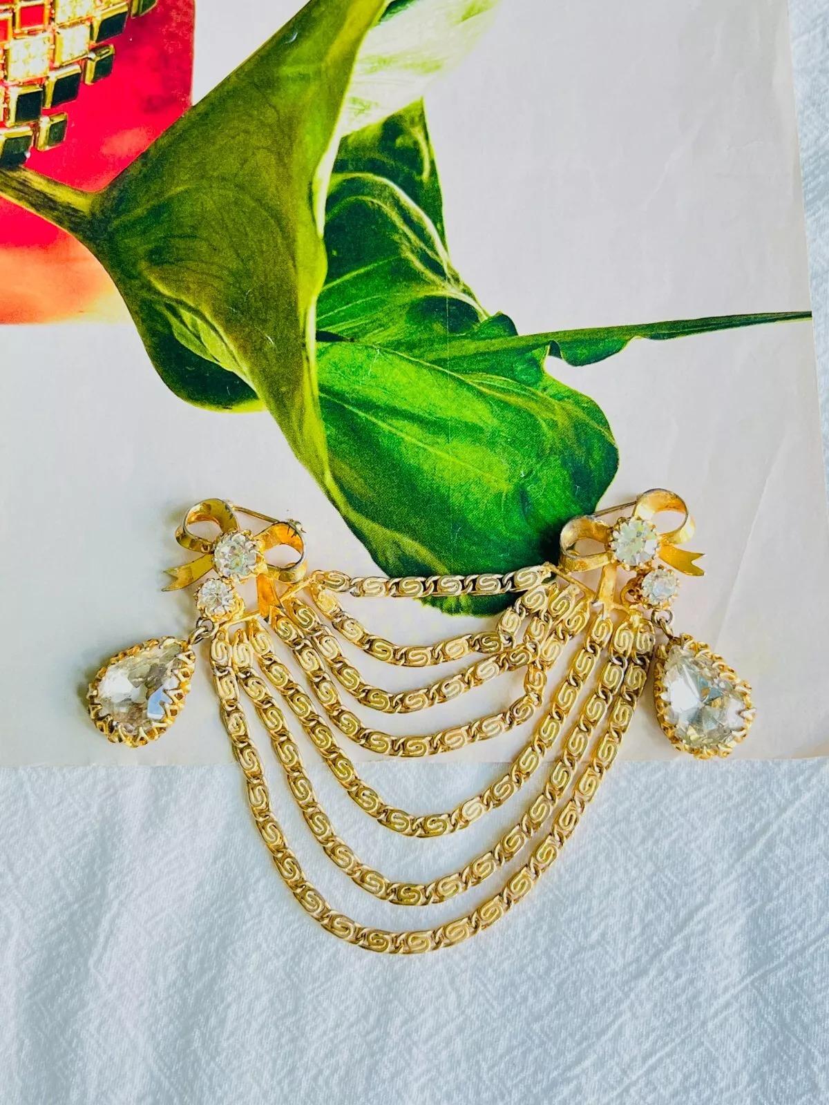 Mitchel Maer for Christian Dior 1951 Baroque Double Knot Bow Tie Swag Tear Drop Crystals 7 Seven Chain Strands Layers Brooch, Placcato Oro 

Mitchel Maer è stato un importante designer americano che ha vissuto in Inghilterra negli anni Cinquanta.