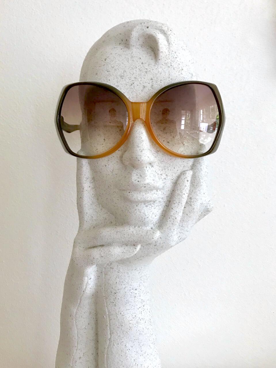 Diese auffällige und extrem seltene Christian Dior D06 Sonnenbrille hat einen übergroßen, zweifarbigen Rahmen in Form eines Schmetterlings. Der Rahmen ist aus Optyl mit einem Farbverlauf von bernsteinfarben bis khaki. Die Kunststoffgläser sind in