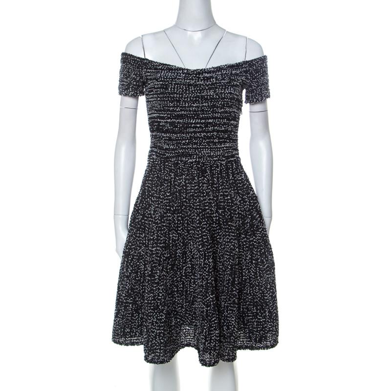 The house of Christian Dior brings to you this fabulous dress to elevate your monochrome obsession. This elegant off-shoulder dress is made of a blend of fine fabrics with a tweed effect all over and features a stunning fit and flare silhouette. It