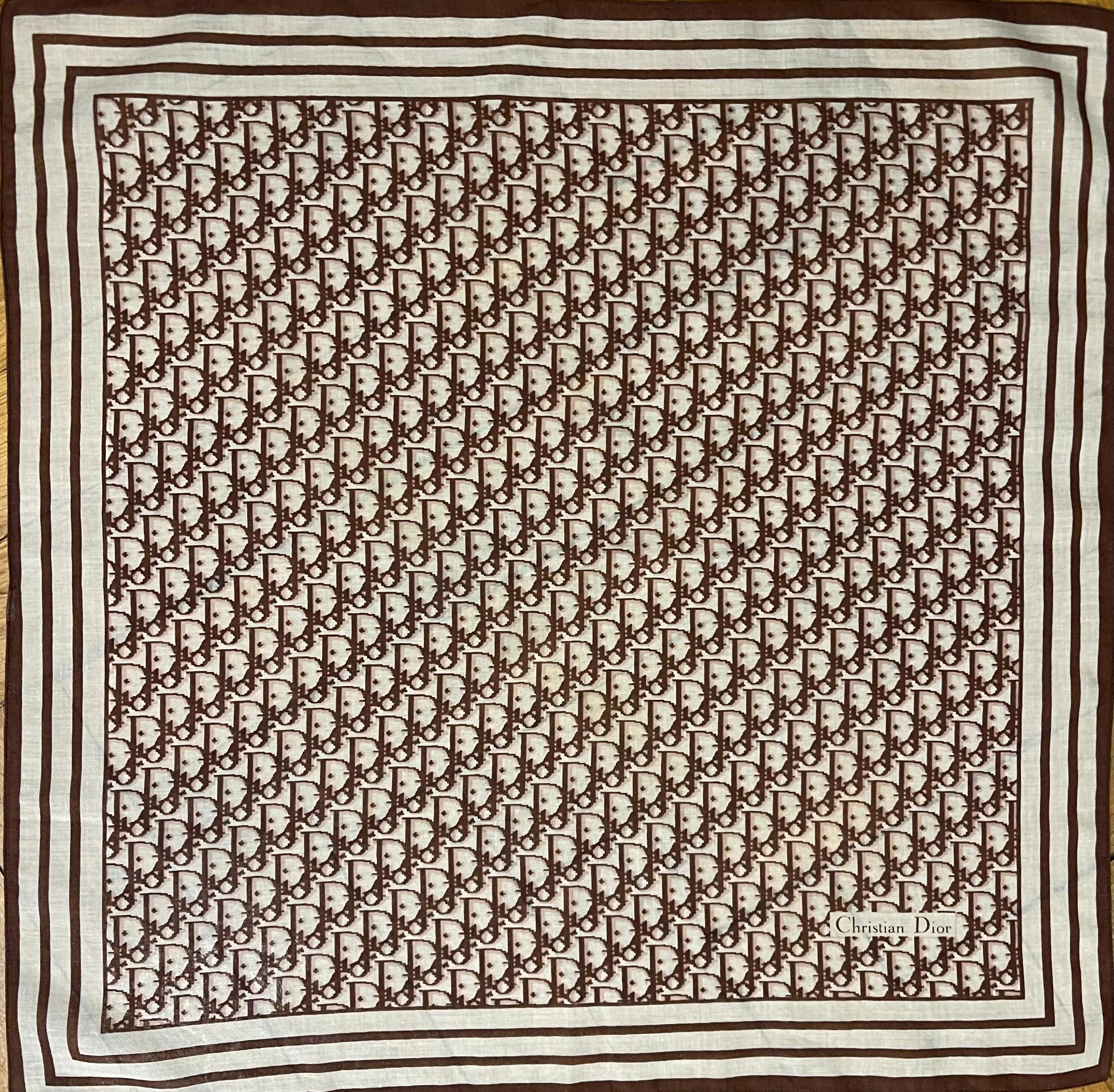 Écharpe en coton Monogram de Christian Dior. Belle écharpe monogramme Dior marron et beige en bon état. Cette écharpe au design emblématique peut être portée de multiples façons différentes grâce à sa taille pratique. 

En bon état. 
22in x 22in. 


