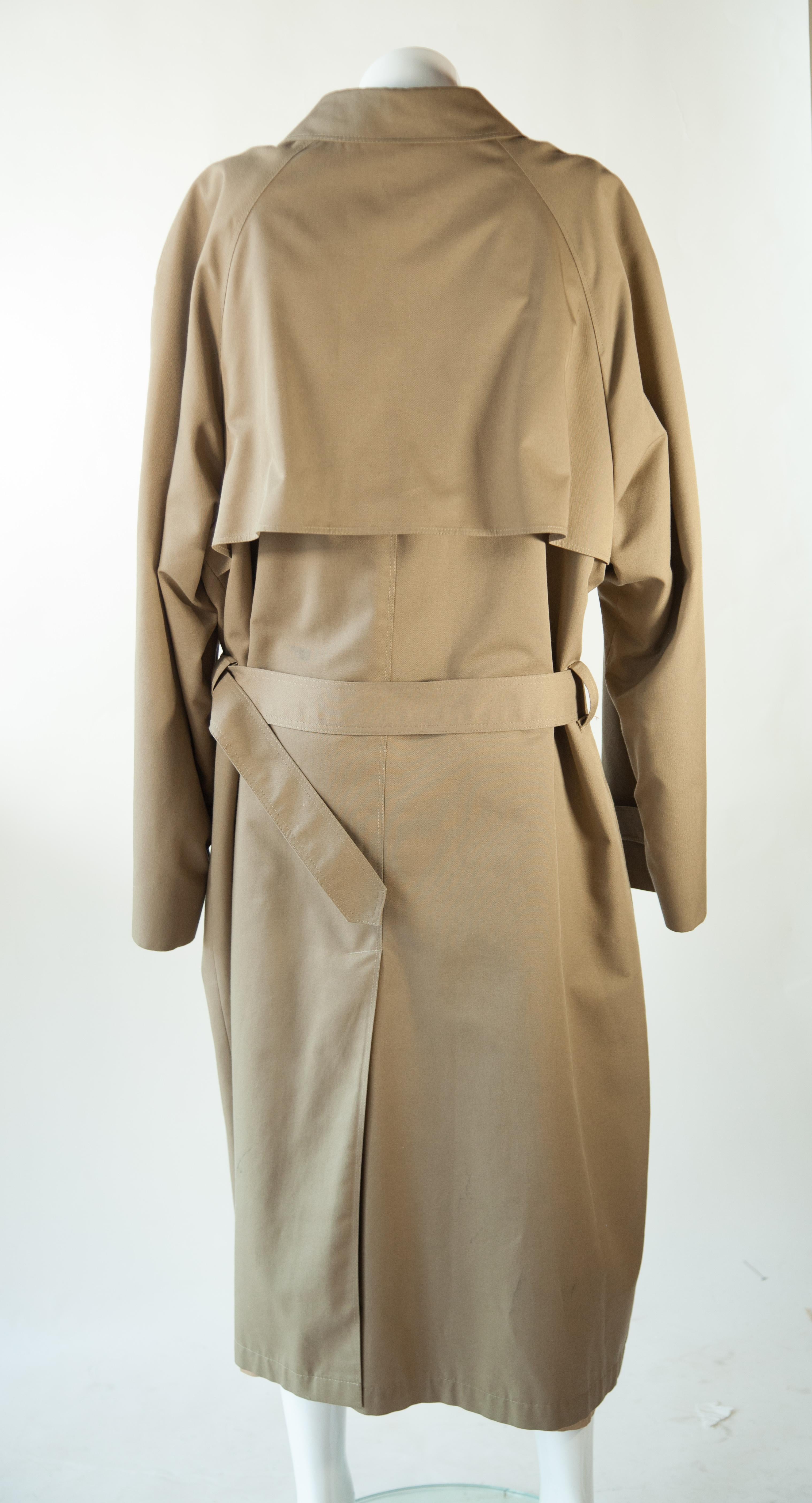The Christian Dior Monsieur Trench Coat offers timeless style and luxury. Crafted from 100% wool, it features a detachable, lined interior for enhanced comfort and versatility. This timeless design is available in size 46R.
