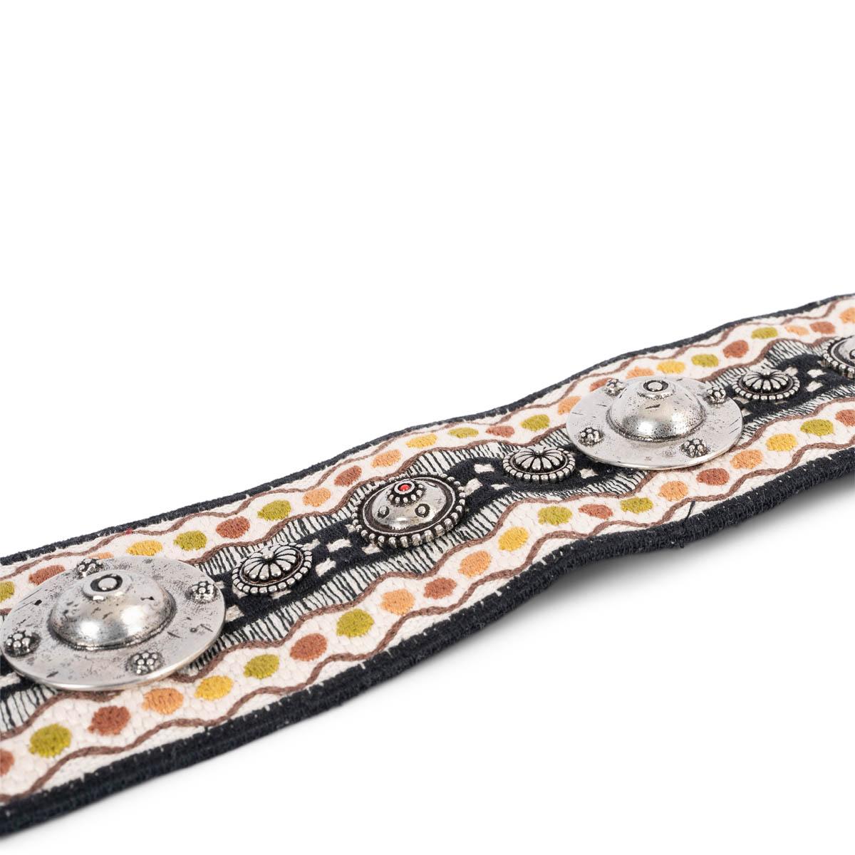 100% authentic Christian Dior Bohemian silver-tone studded metal emblems belt strap in shades of black, white, lime, brown and mustard canvas featuring gold-tone clasps and black leather trimming. Has been carried and is in excellent condition.