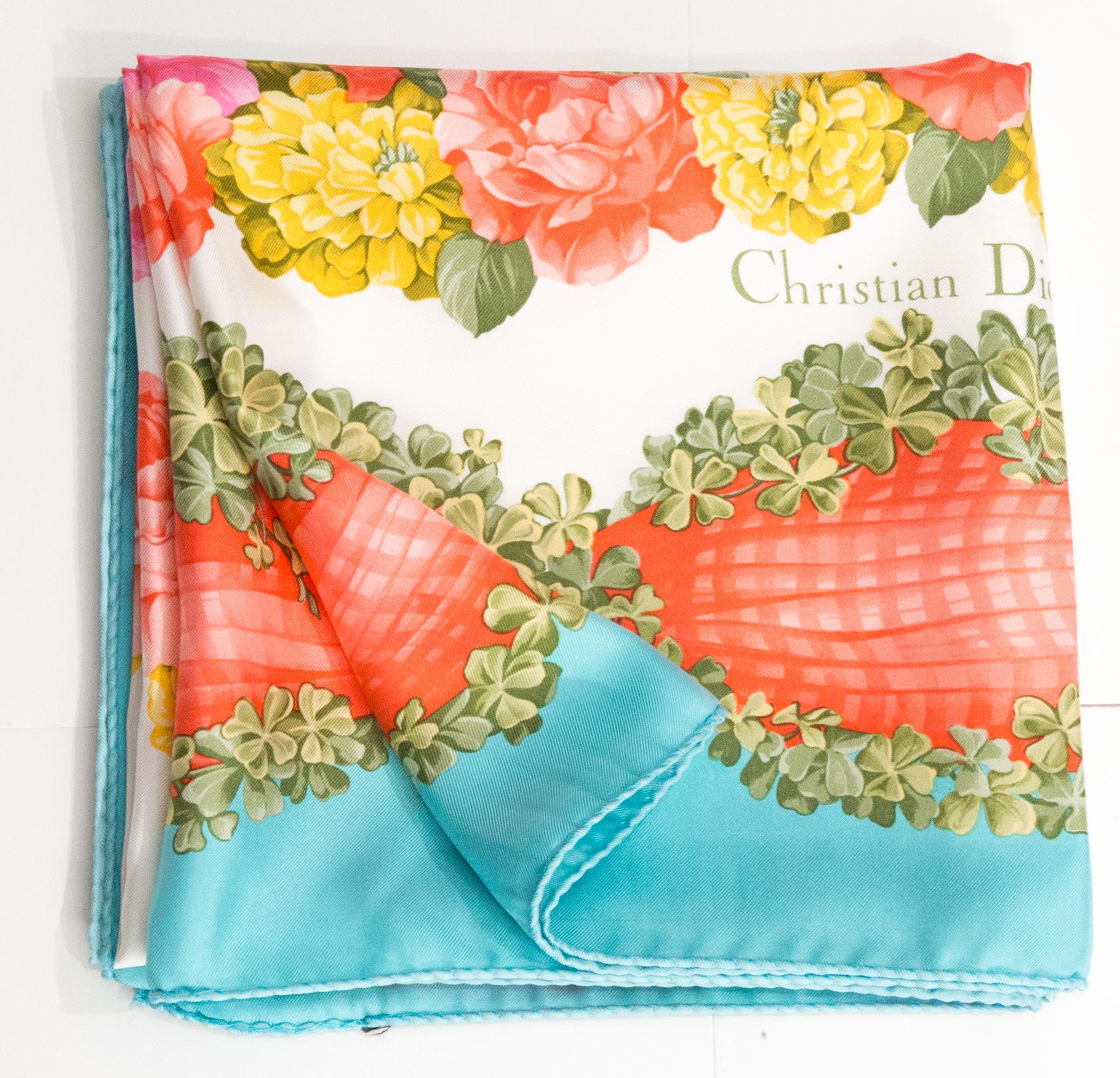 Christian Dior Multicolor floral Silk Scarf featuring a turquoise border, a flowers motive, a Christian Dior signature. 
Circa 1990s
In good vintage condition. Made in France.
35in (89cm)  X 35in (89cm)
We guarantee you will receive this  iconic