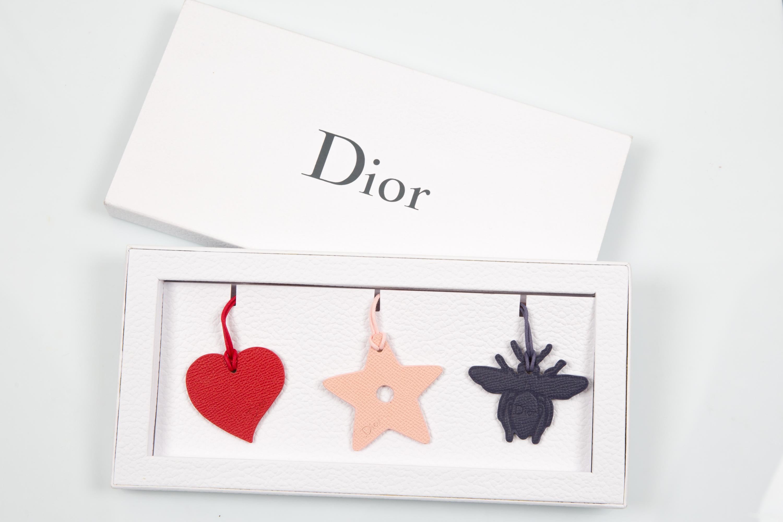 Christian Dior Charms en cuir multicolore comprenant 3 charms en cuir, avec des bretelles en dentelle de coton, livré dans sa boîte d'origine. 
Circa 2000s  Fabriqué en France
Excellent état vintage. 
Longueur : 2,7 pouces (7 cm)
Hauteur : 2,3