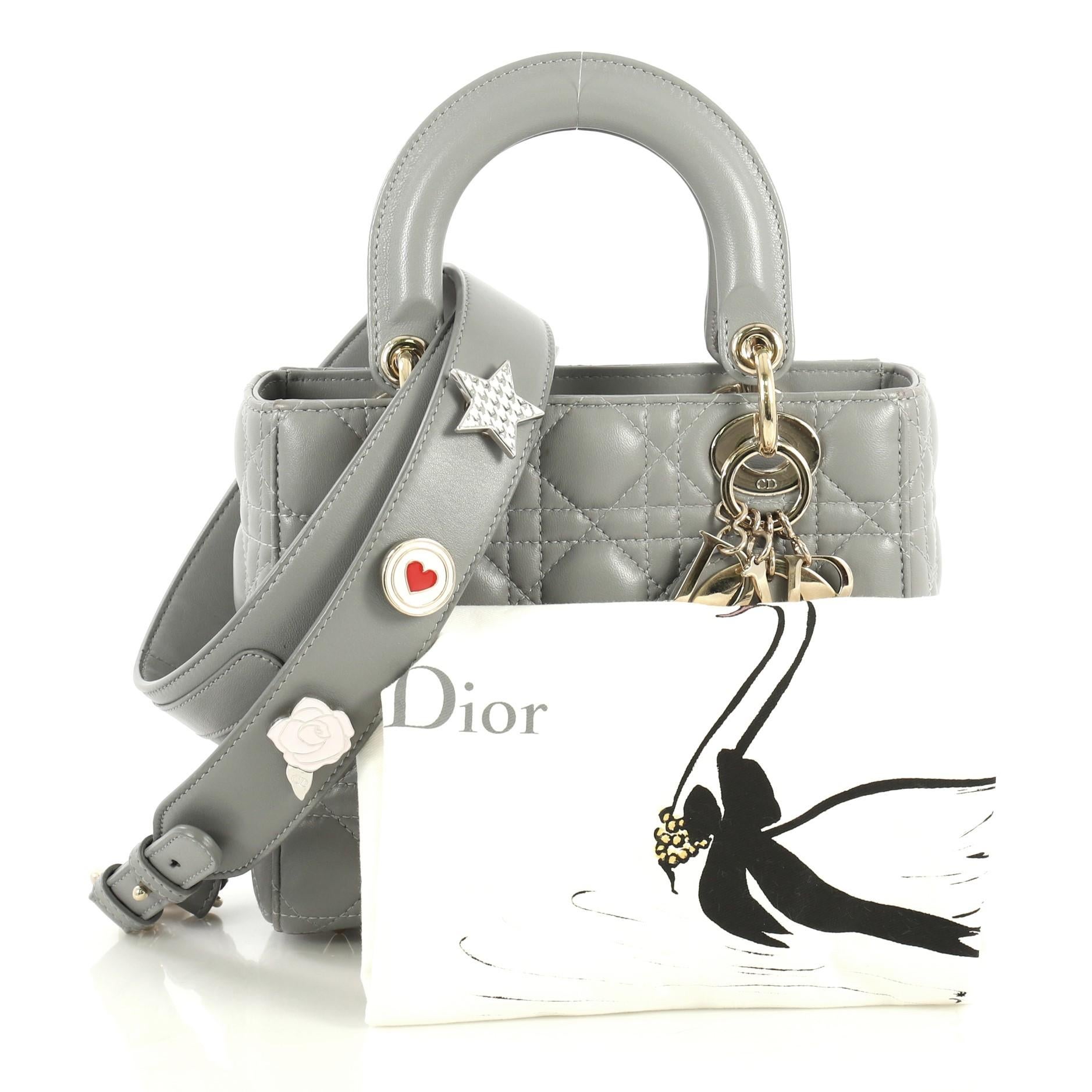 This Christian Dior My Lady Dior Bag Cannage Quilt Lambskin, crafted from gray cannage quilted lambskin, features short dual handles with Dior charms and gold-tone hardware. It opens to a neutral fabric interior with zip pocket. 

Estimated Retail