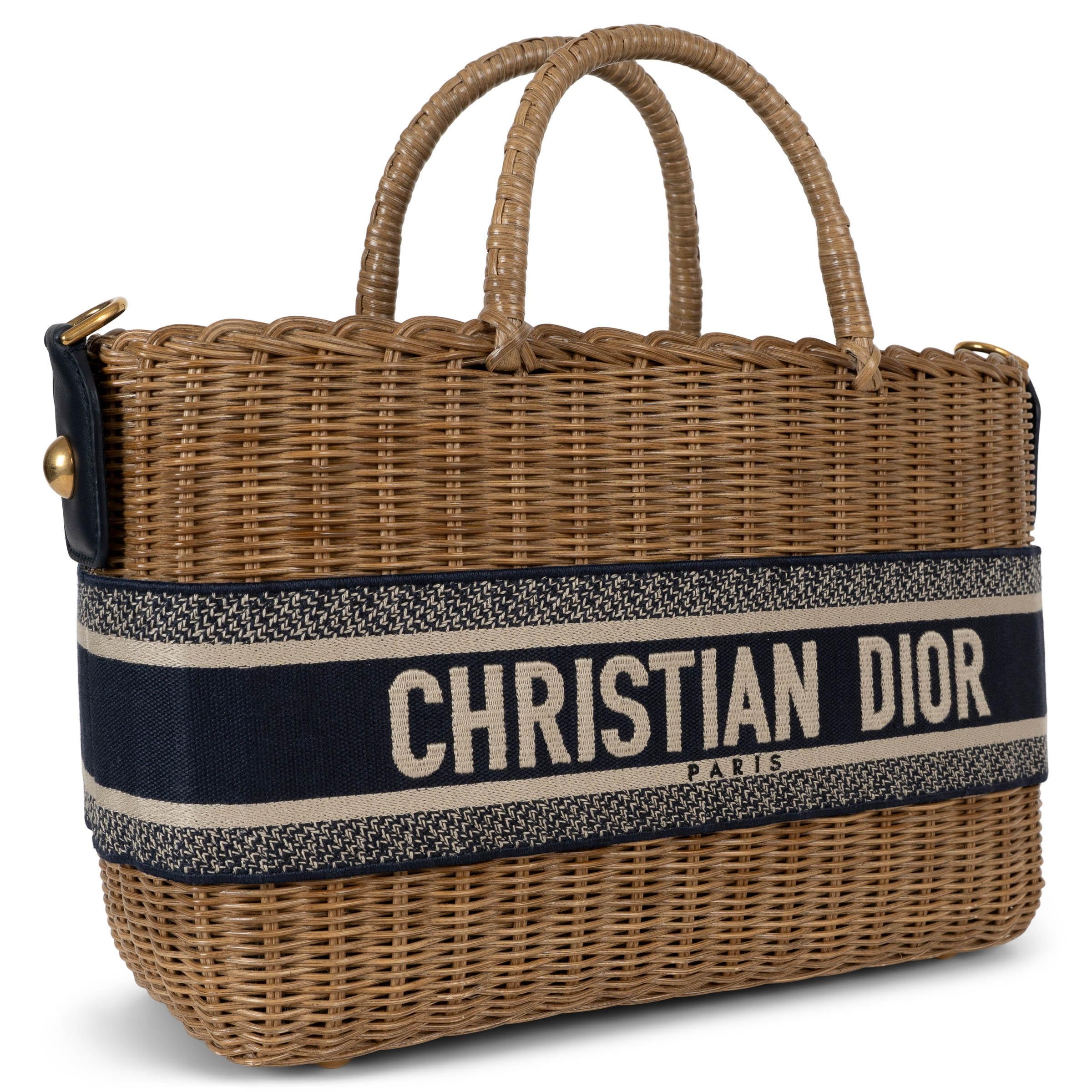 Diese 100% authentische Christian Dior Korbtasche ist aus natürlichem Weidengeflecht gefertigt und mit einem navyblauen Jacquard-Signaturband verziert. Sie verfügt über zwei Griffe an der Oberseite und einen abnehmbaren, verstellbaren breiten