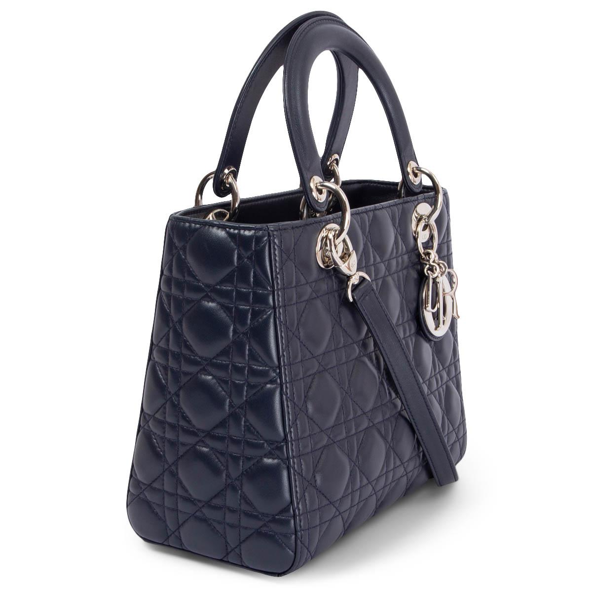 100% authentic Christian Dior Medium Lady Dior shoulder bag in navy blue cannage lambskin featuring silver-tone hardware. Opens with a zipper on top and is lined in navy blue classic Dior nylon with one zipper pocket against the back. Comes with a