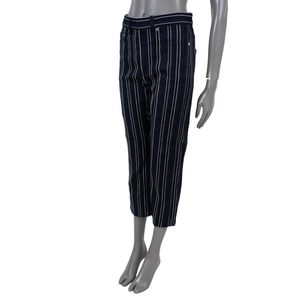 100% authentic Christian Dior striped cropped jeans in navy blue, black and cream cotton (100%). Features slit pockets on the front and back and belt loops. Open with a zipper and a hook on the front. Have been worn and are in excellent condition.