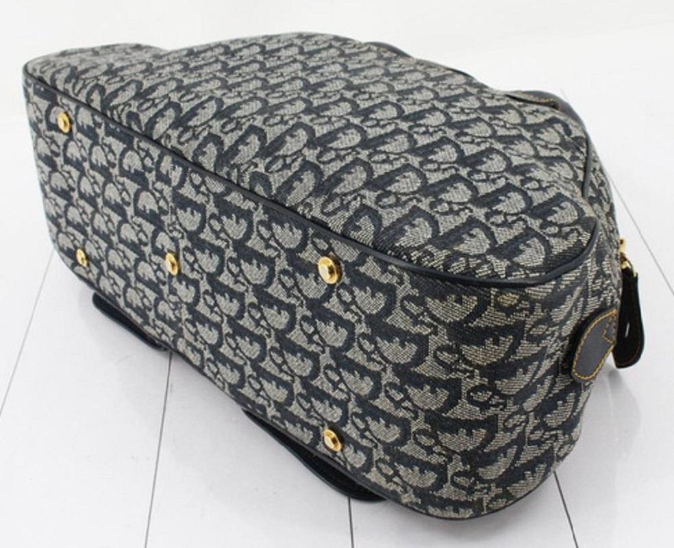 Die Christian Dior Saddle Medium Bowler Bag ist aus marineblauem Diorissimo Canvas gefertigt und verfügt über zwei gerollte, marineblaue Lederhenkel, schützende Bodennieten, einen überkreuzten Riemen mit Dior-Verschluss und goldfarbene Beschläge.
