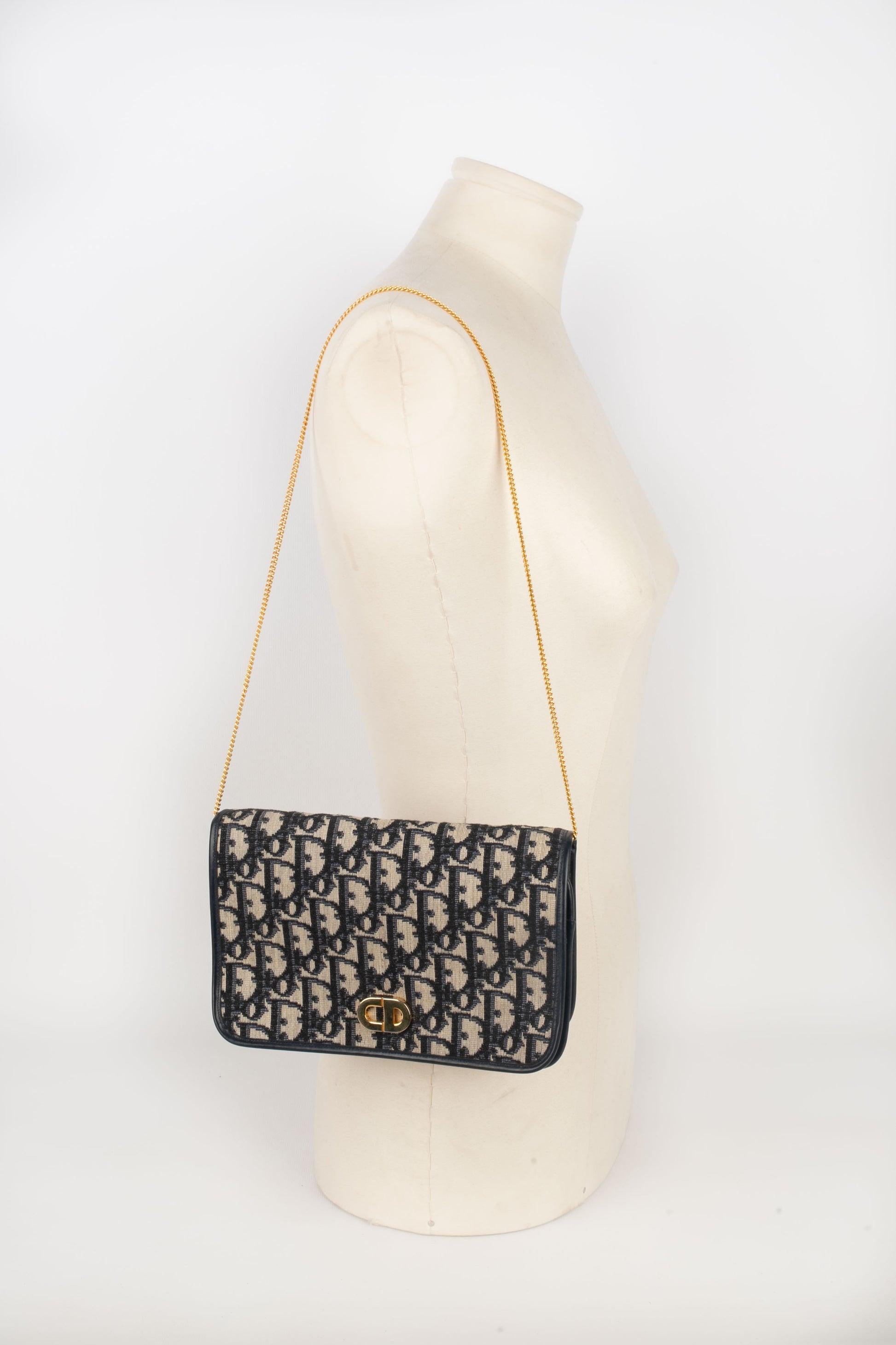 Dior -(Made in France) Navy-blue leather and monogrammed canvas bag with a golden metal chain strap.

Additional information:
Condition: Good condition
Dimensions: Length: 21 cm - Height: 13 cm - Depth: 4 cm - Handle: 66 cm

Seller Reference: S248
