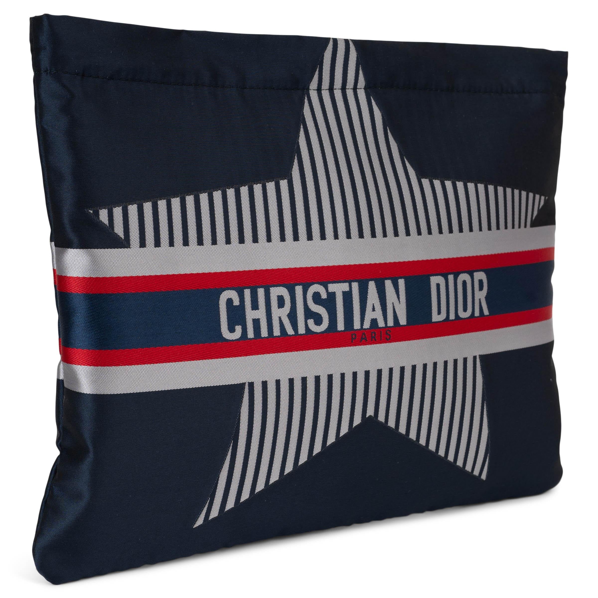 This 100% authentic Christian Dior DiorAlps pouch in navy blue nylon is a sporty yet sophisticated accessory inspired by alpine elegance. Featuring a bold white striped star and the iconic signature band, it captures the spirit of the DiorAlps
