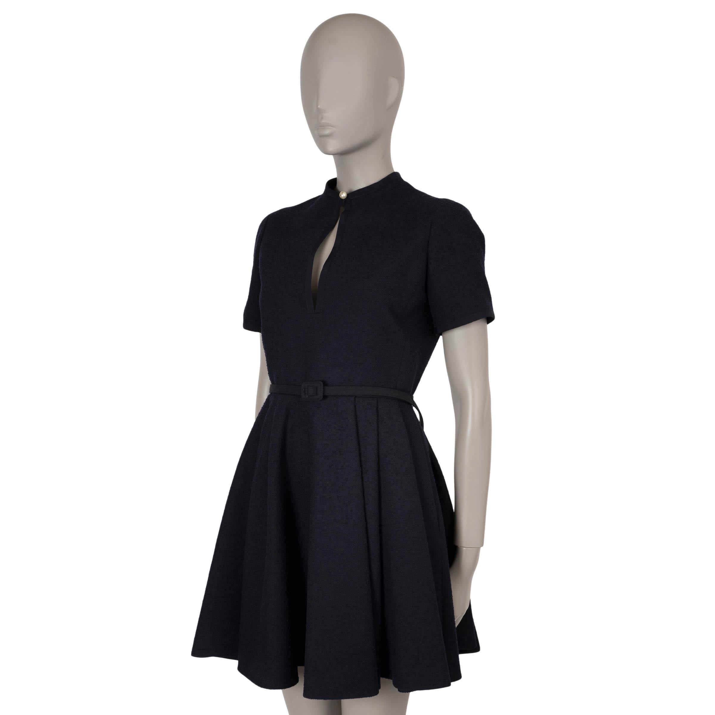 Este vestido bouclé 100% auténtico Christian Dior de lana azul marino (70%), algodón (23%) y poliamida (7%) encarna la quintaesencia de la elegancia Dior con un toque moderno. Presenta una silueta ajustada con una elegante longitud mini, y se