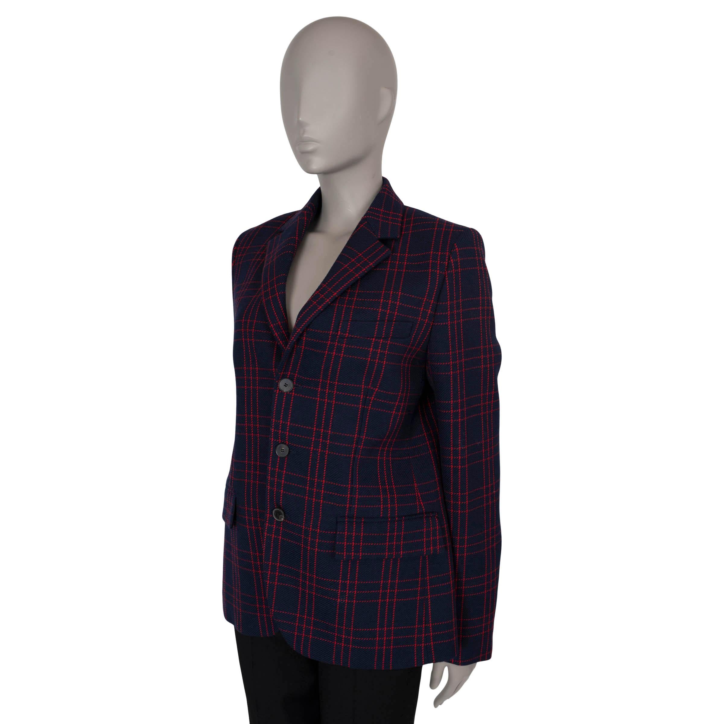 This 100% authentic Christian Dior plaid blazer in navy blue and red wool (100%) combines a preppy aesthetic with a modern edge. It features notched lapels, buttoned cuffs, a chest pocket, and two flap pockets at the waist, striking a balance