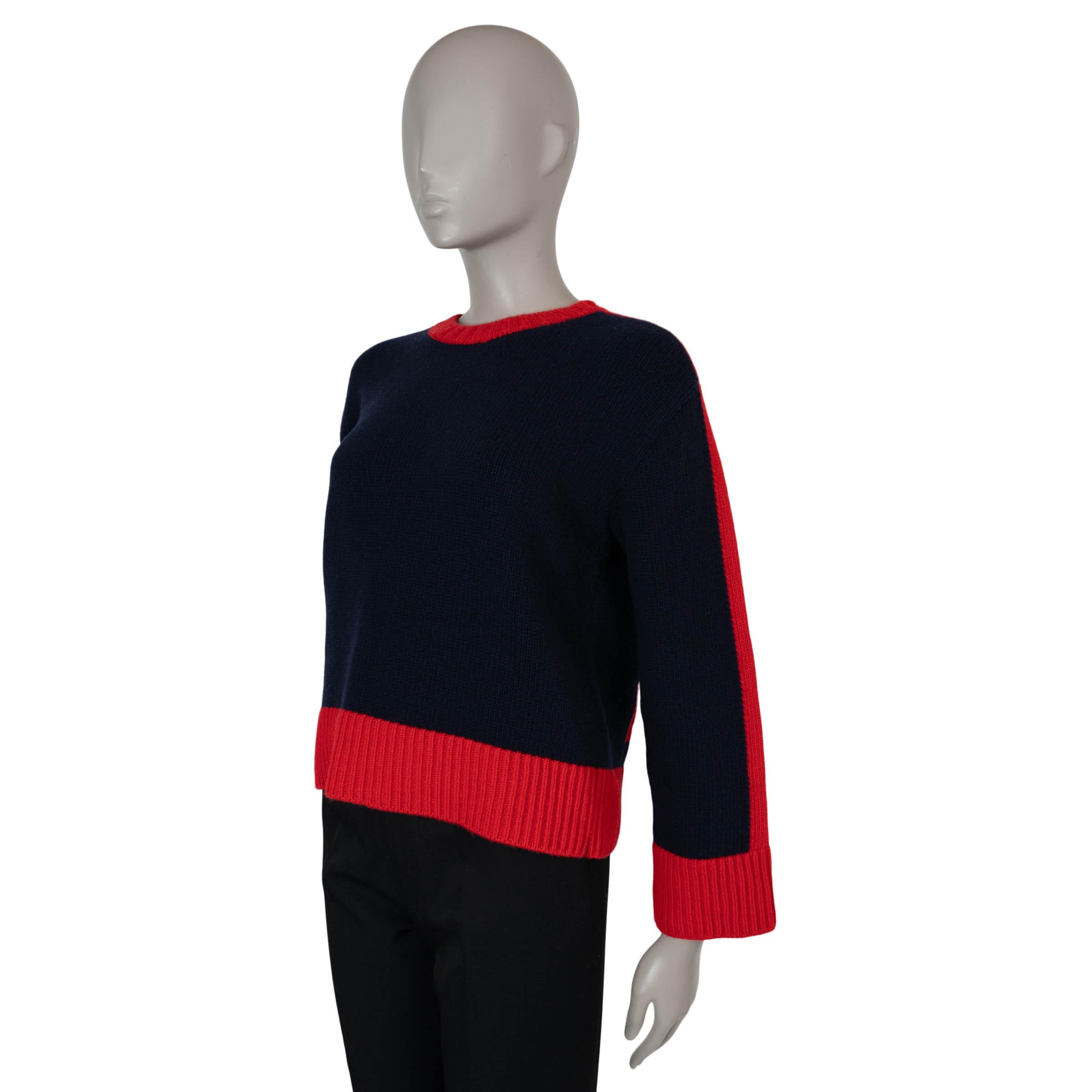 Este jersey J'Adior 8 100% auténtico Christian Dior de lana azul marino y roja (70%) y cachemira (30%) combina el lujo sin esfuerzo con un toque deportivo. Diseñado con una silueta de gran tamaño, presenta hombros caídos, mangas anchas, cuello