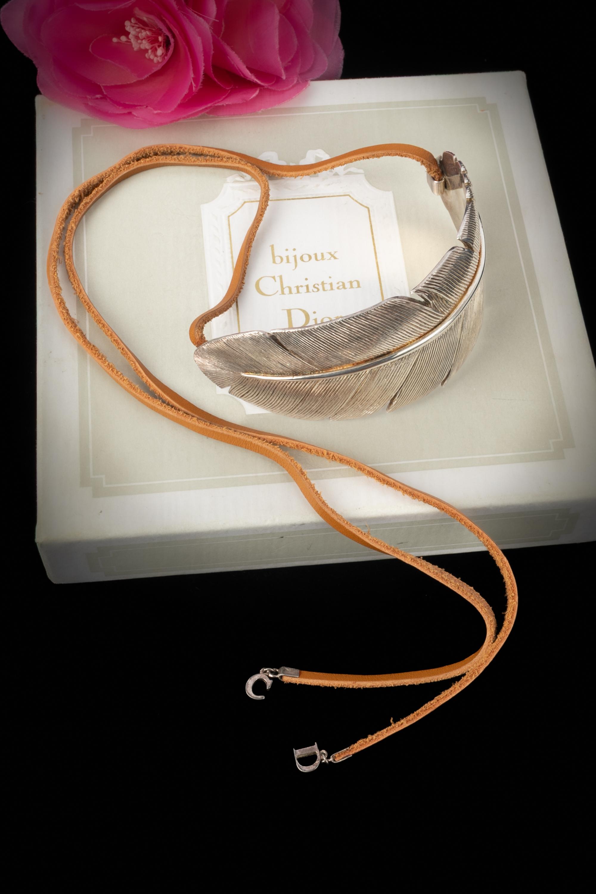 DIOR - (177g) 925-sterling silvery necklace with a feather, tied with two brown leather laces. 2002 Spring-Summer Collection under the artistic direction of John Galliano.

Condition:
Very good condition

Dimensions:
Feather length: 15 cm - Lace