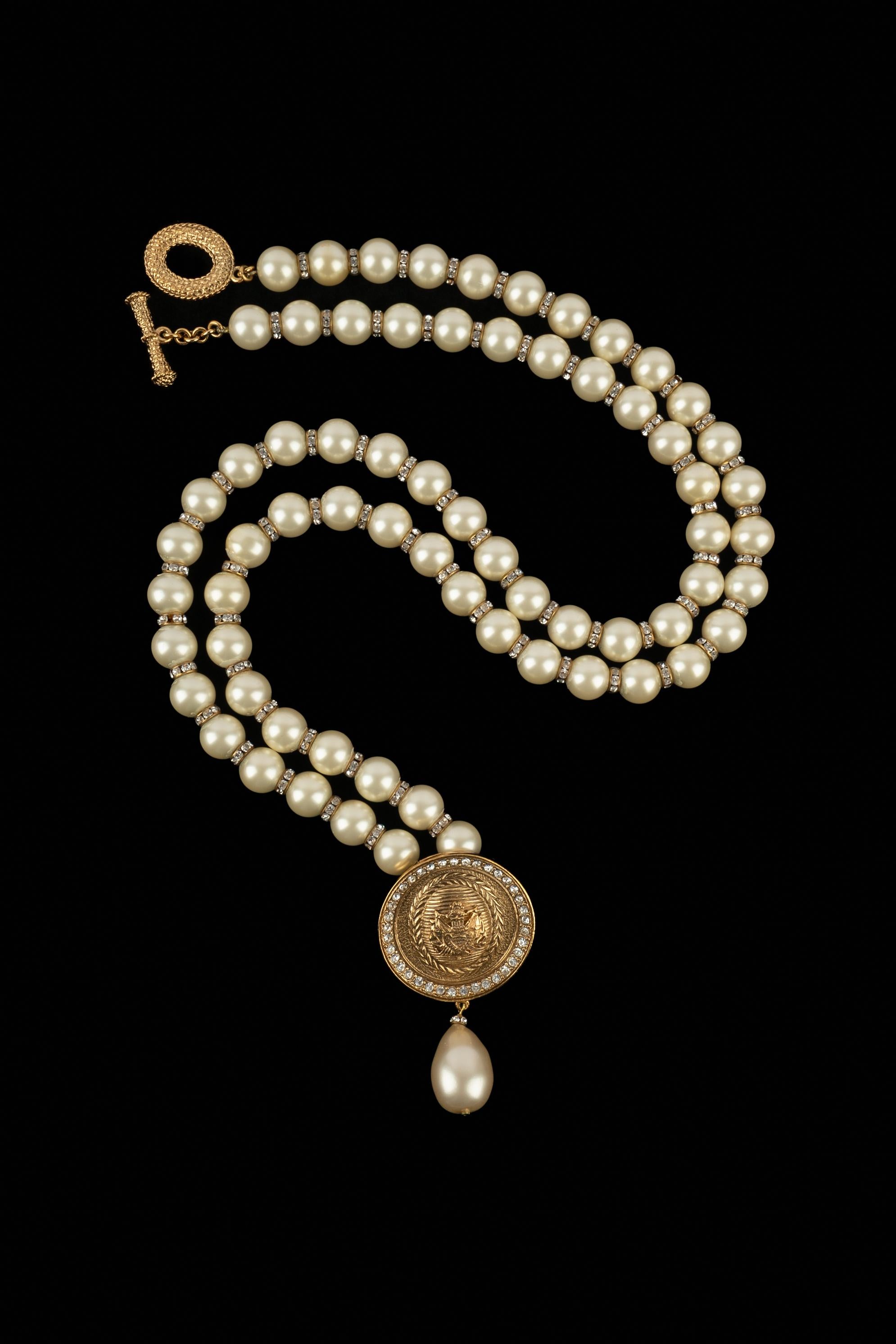 DIOR - Collar largo de perlas de fantasía con anillos de metal dorado con strass, unido a un colgante circular de metal dorado adornado con strass y una gota de perlas de fantasía.

Estado:
Muy buen estado

Dimensiones:
Longitud: 117 cm

SKU:BC282
