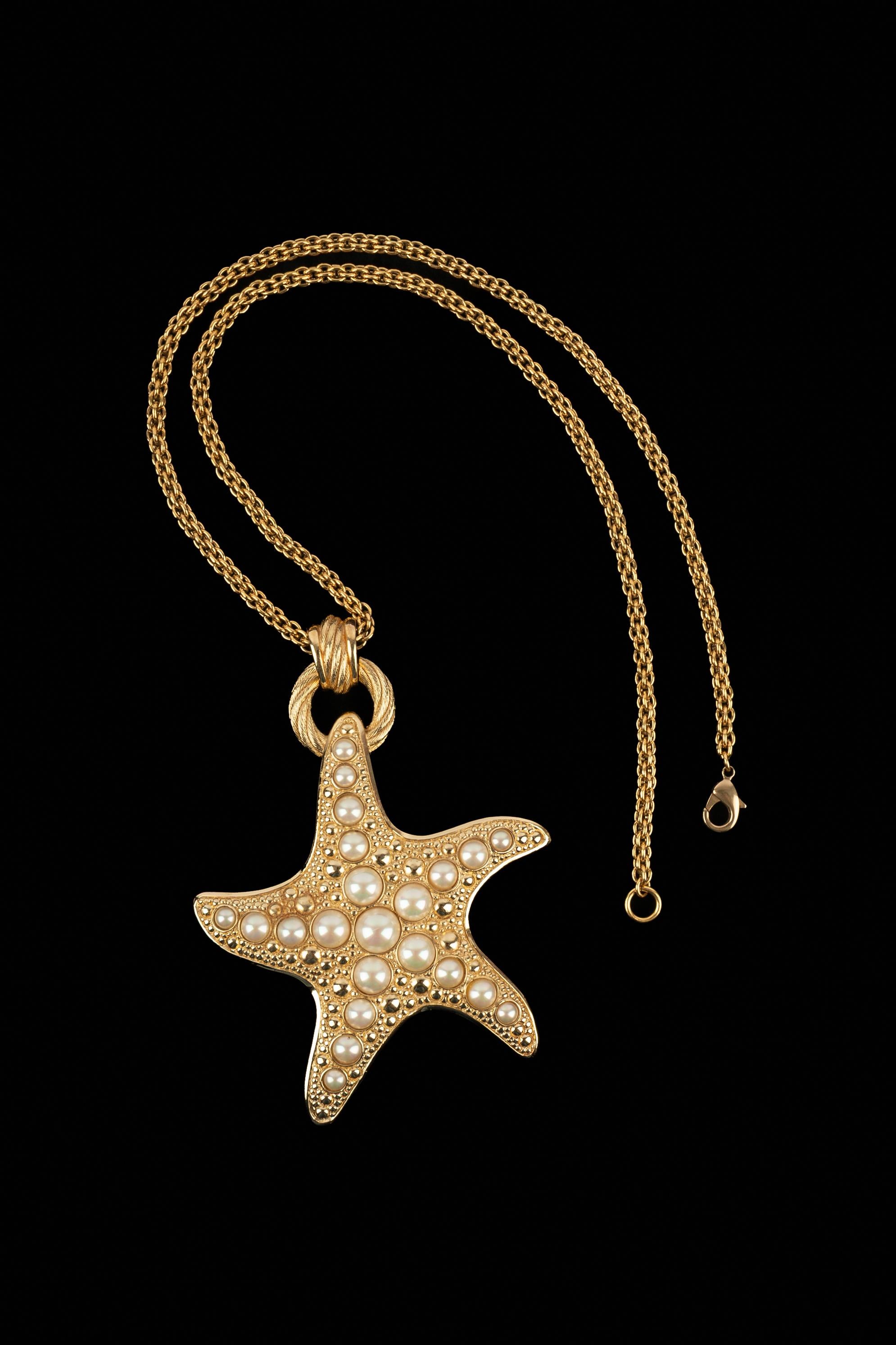 DIOR - Collana a catena in metallo dorato con un imponente ciondolo a forma di stella marina in metallo dorato ornato da cabochon perlati in costume.

Condizioni:
Ottime condizioni

Dimensioni:
Lunghezza: 75 cm

SKU:BC279


