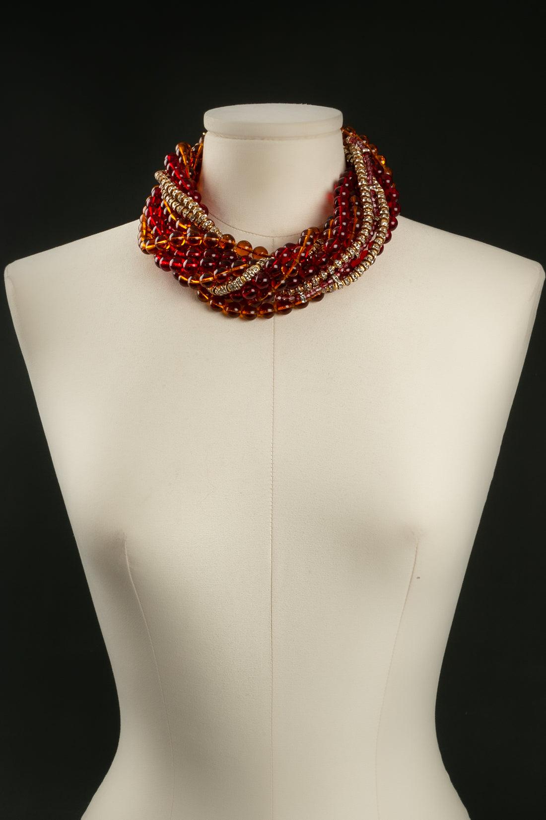 Christian Dior - Collier court en métal doré composé de perles en pâte de verre dans les tons rouge et orange avec des entretoises. Le fermoir est en métal doré ajouré et pavé de strass.

Informations complémentaires : 

Dimensions : 
Longueur : 45