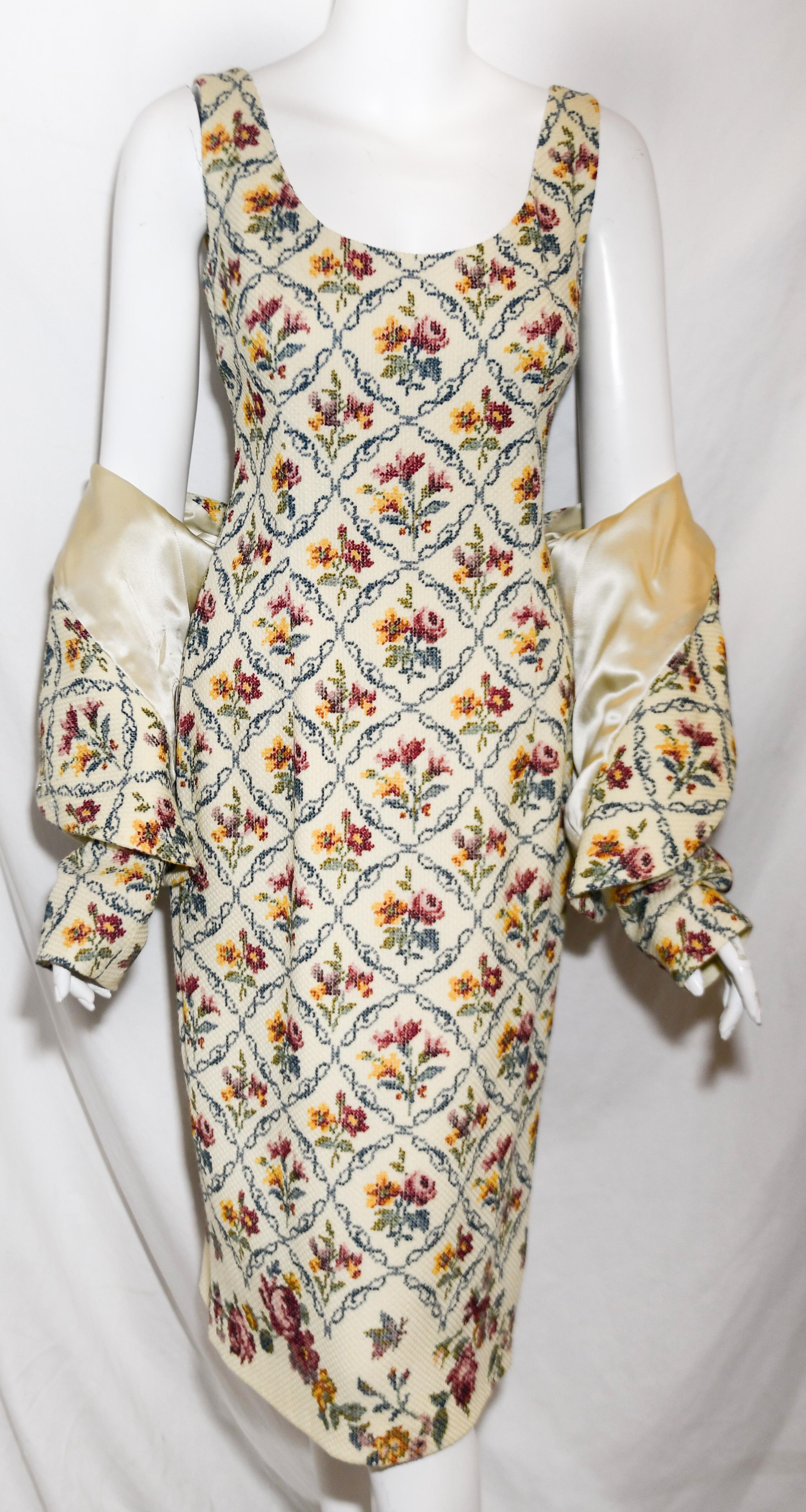 Christian Dior 2 piece needle point floral print ensemble contains a midi dress and a cropped jacket.  This suit with its unique needle point print takes us back to the nostalgia of the hand stitched work of our grandmothers now with a new and