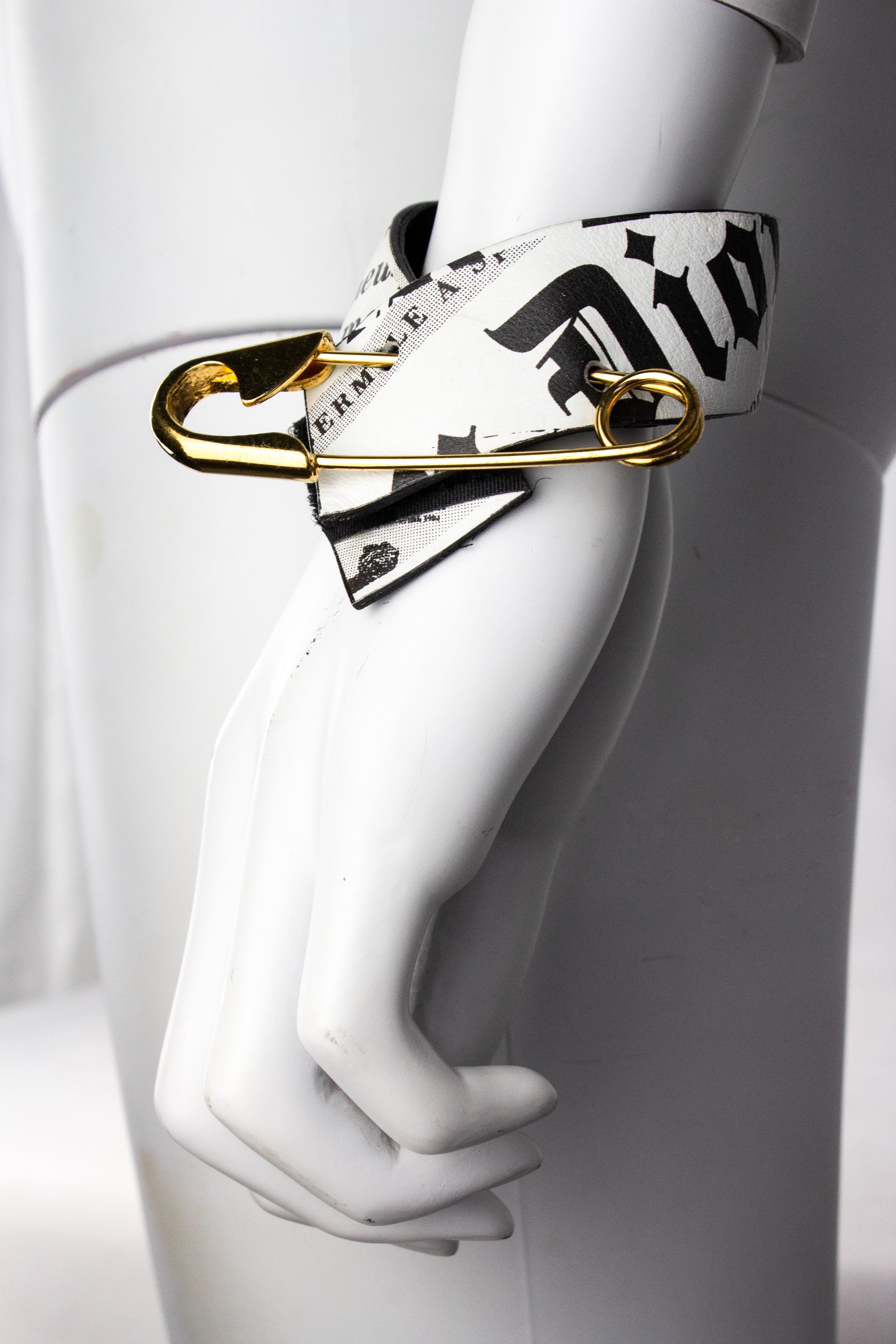 Rare vintage Christian Dior by John Galliano newspaper print bracelet, from the Fall/Winter 2000 'Fly Girl' collection. Features a velcro closeure and giant gold toned safety pin detail.

Condition
Excellent