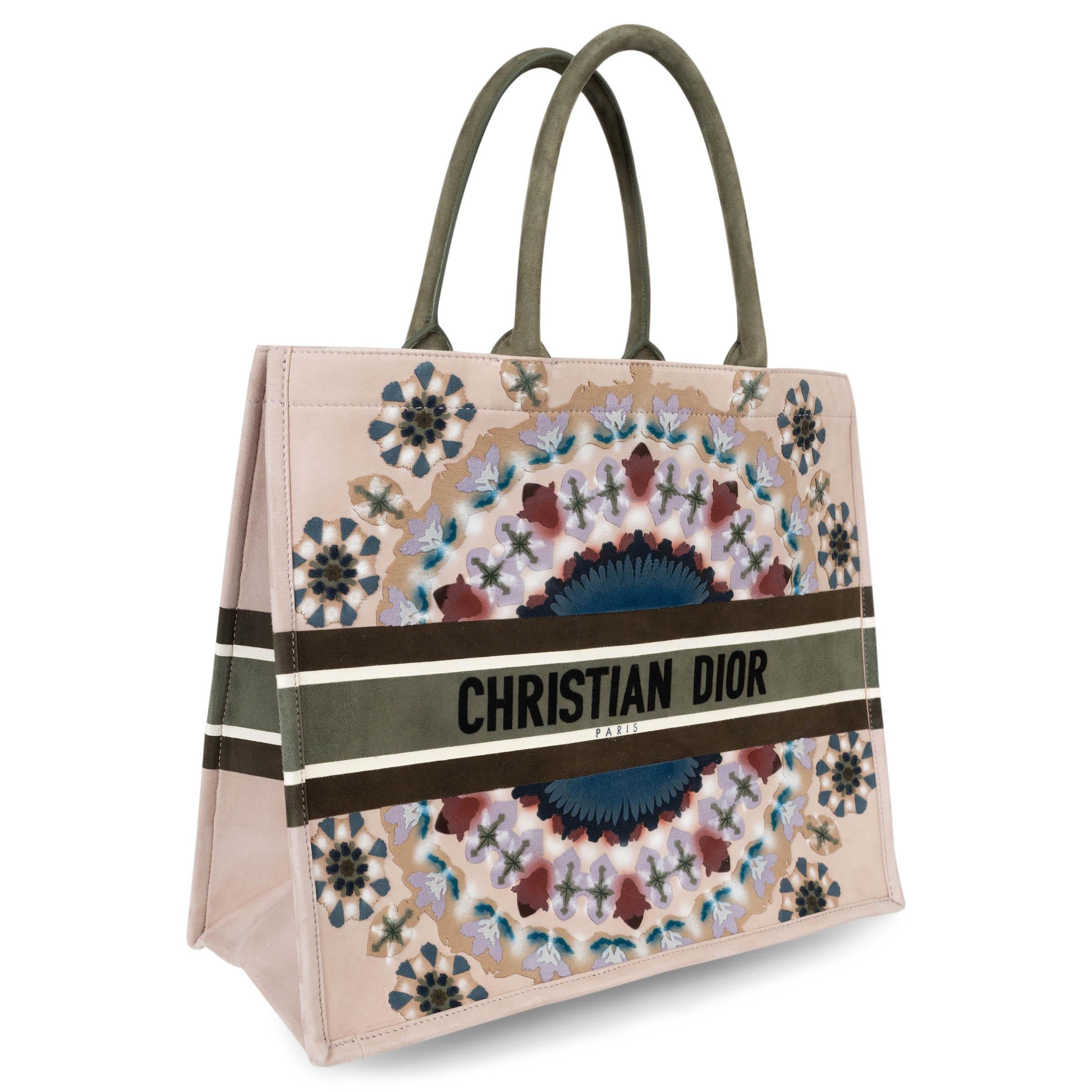 Ce Large Book Tote Christian Dior 100% authentique en daim nude est une expression audacieuse de l'art de la maison, avec l'imprimé vibrant KaléiDiorscopic dans des tons bleu, bordeaux, lilas pâle, pétrole et vert olive. La signature emblématique de