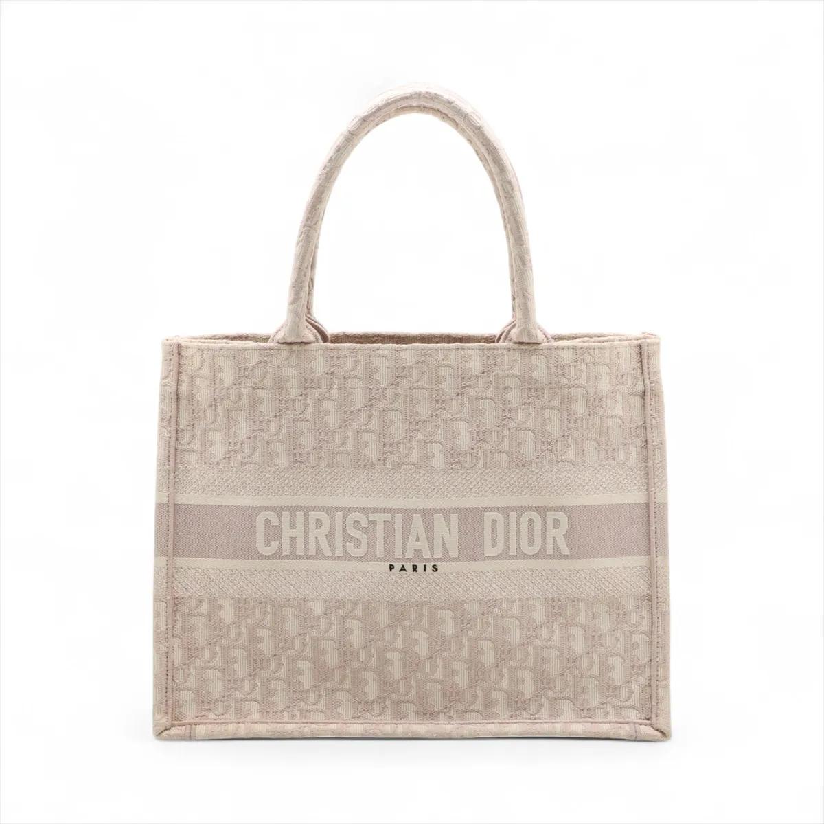 La borsa Christian Dior Oblique Book Tote Medium Canvas Bag in rosa è un accessorio sofisticato ed elegante che riflette il design iconico della maison. Realizzato in tela resistente, presenta l'inconfondibile motivo Oblique di Dior nei toni del