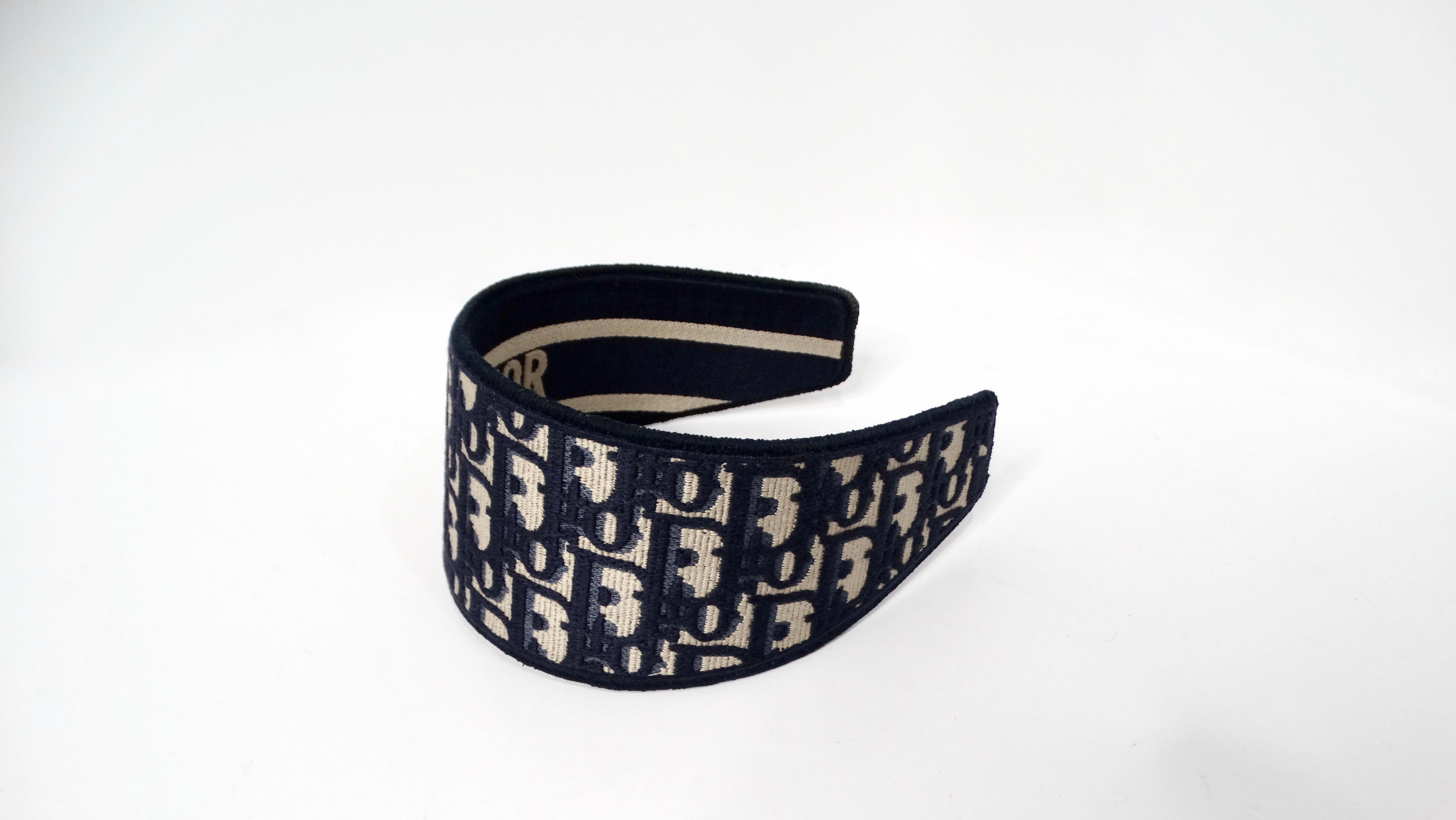 The Christian Dior Oblique Jacquard Navy Blue & Tan Wide Structured Headband embodies the luxury and sophistication synonymous with the Dior brand. Crafted with exquisite attention to detail, the headband features a stunning jacquard pattern that