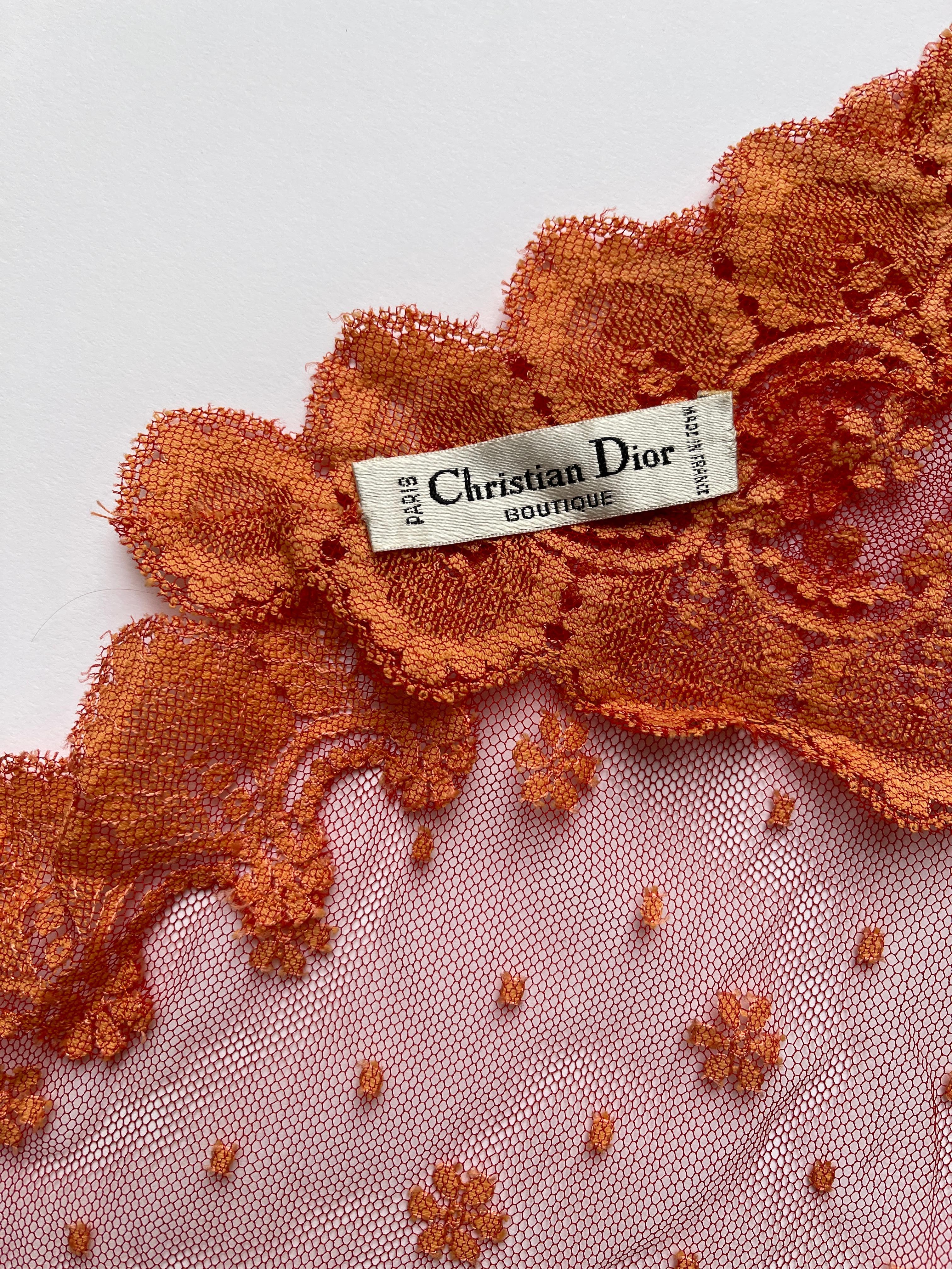 CHRISTIAN DIOR, Made in France, Early 2000's.
Beautiful lace mantilla in orange tones. 
Small flowers on the center framed by a lighter orange lace.
The larger part of the triangle is 126cm - the two others are 76cm.
Very Good condition

Every item