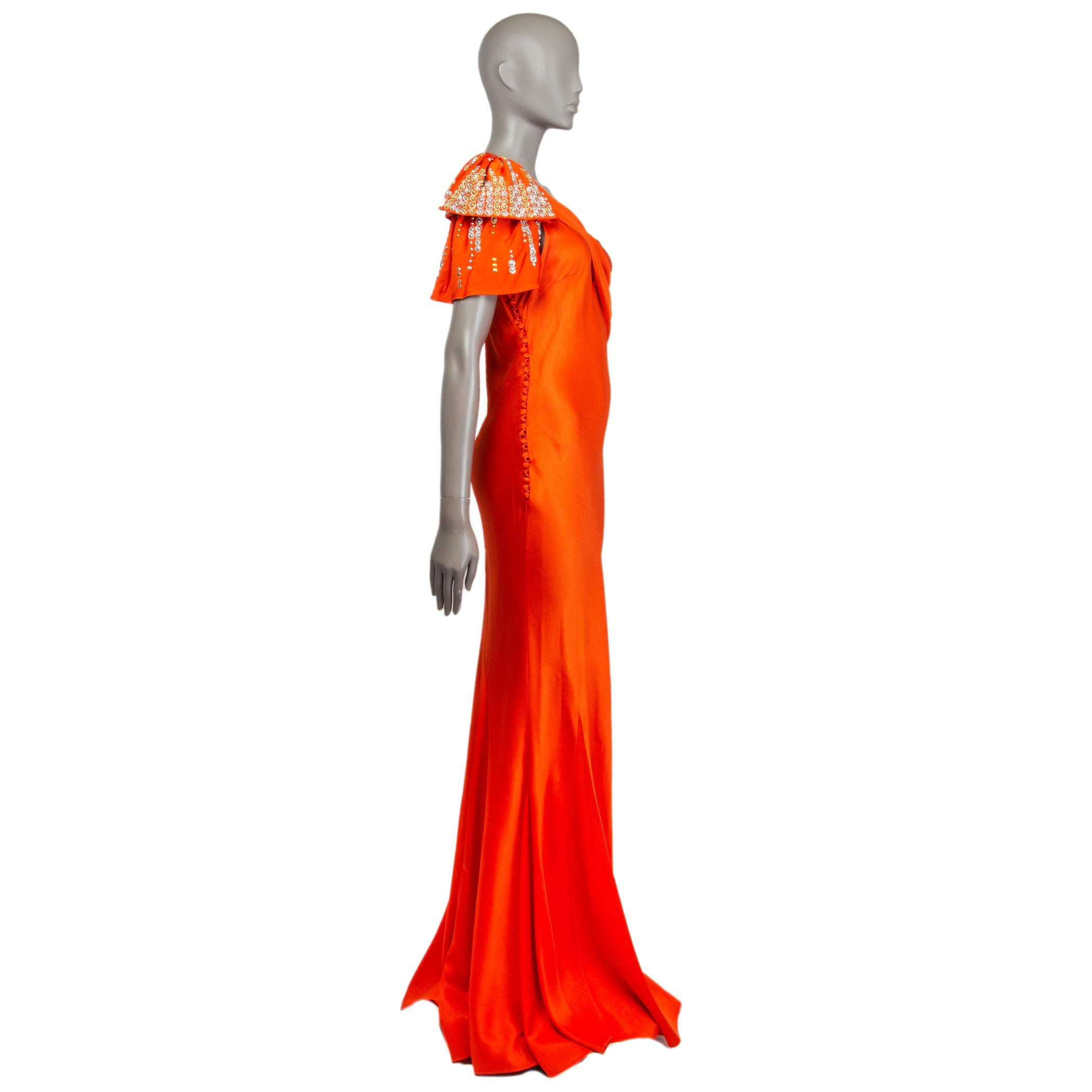 Christian Dior one-shoulder gown in orange satin acetate (68%) and viscose (32%). With godet skirt and beaded shoulder draping that pleats diagonally around the bust. Closes with one hool and fabric-lined buttons down the side. Unlined. Has been