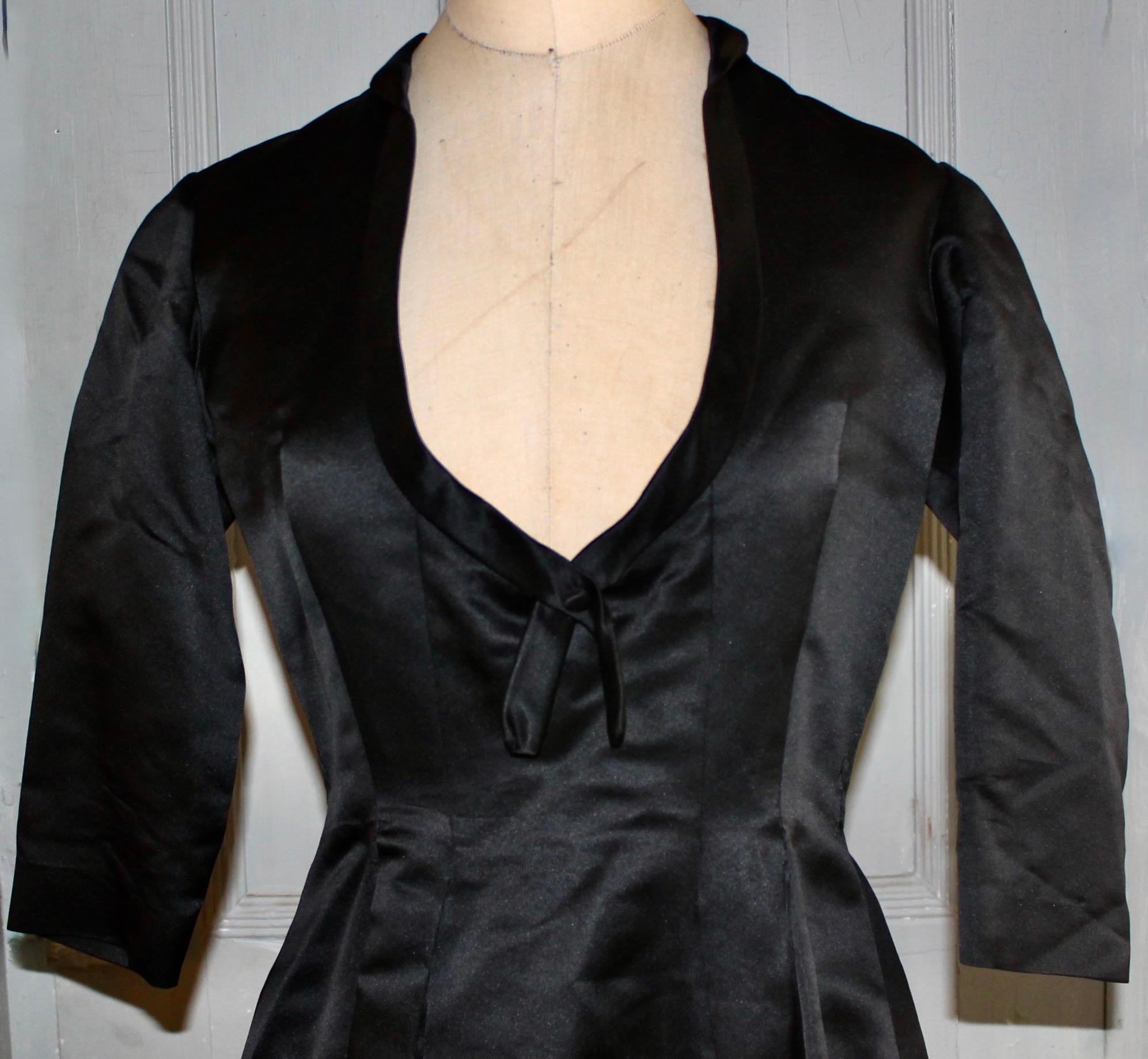 A Christian Dior-New York (founded in 1948) black silk/satin evening dress. Bearing a Christian Dior Original made in USA Christian Dior-New York Label, (50's labels) and a Nan Duskin Philadelphia label. Approximate size 6-8 American.