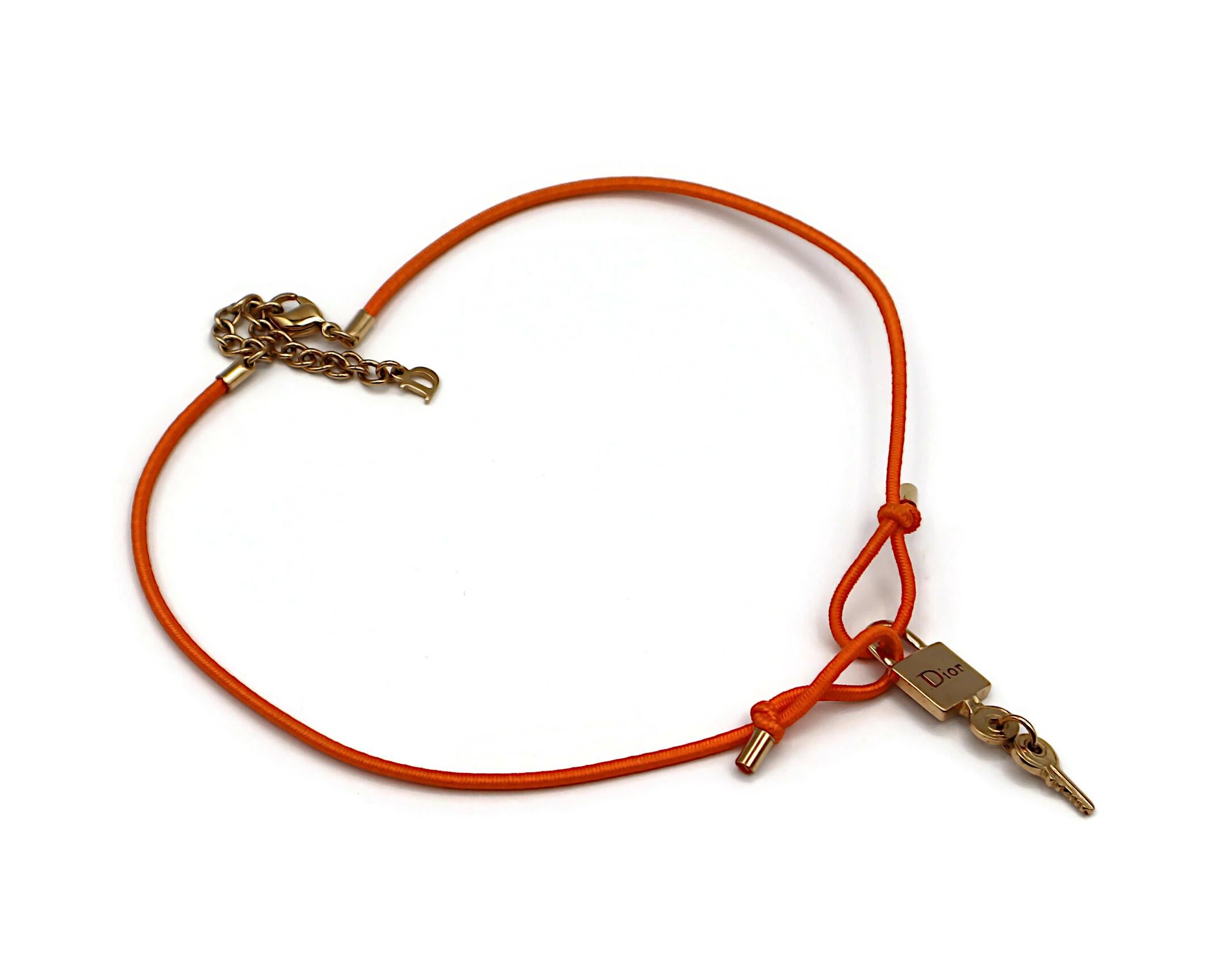 Collana girocollo CHRISTIAN DIOR con lucchetto DIOR in oro e chiavi abbinate, cinturino elastico arancione.

Chiusura a moschettone.
Lunghezza regolabile.

DIOR in rilievo.

Misure indicative (senza estensione): lunghezza regolabile da circa 33 cm