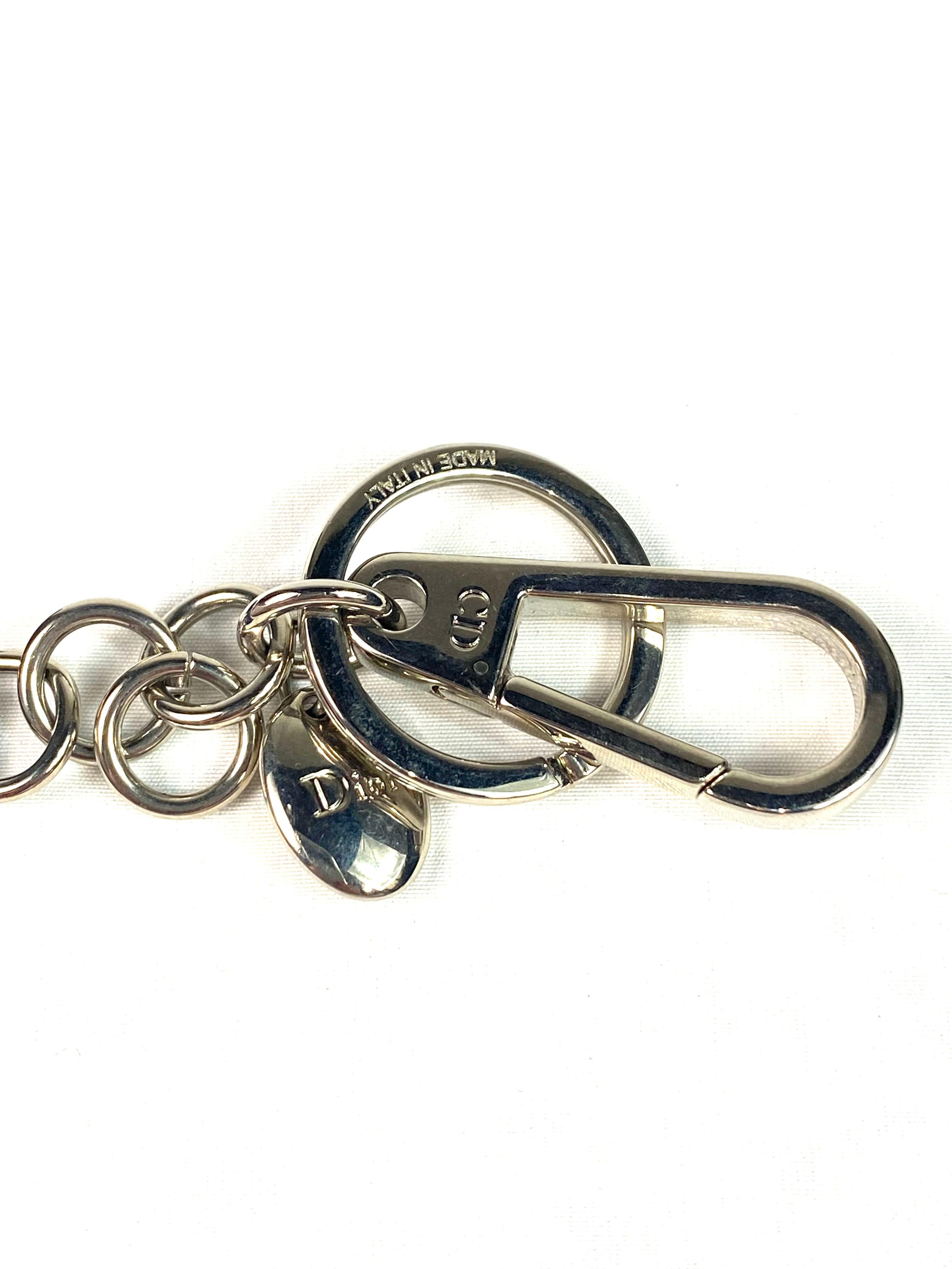 Product details:

The key chain features blue sequins and black embroidered writing on the top and black leather on the back with silver tone hardware.